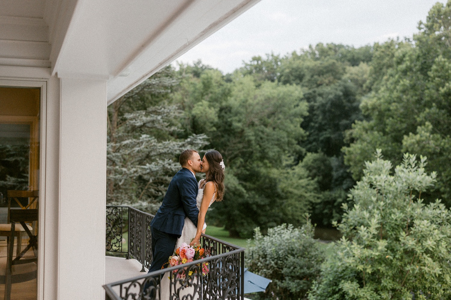 bride and groom kissing on balcony dreamy backyard wedding
