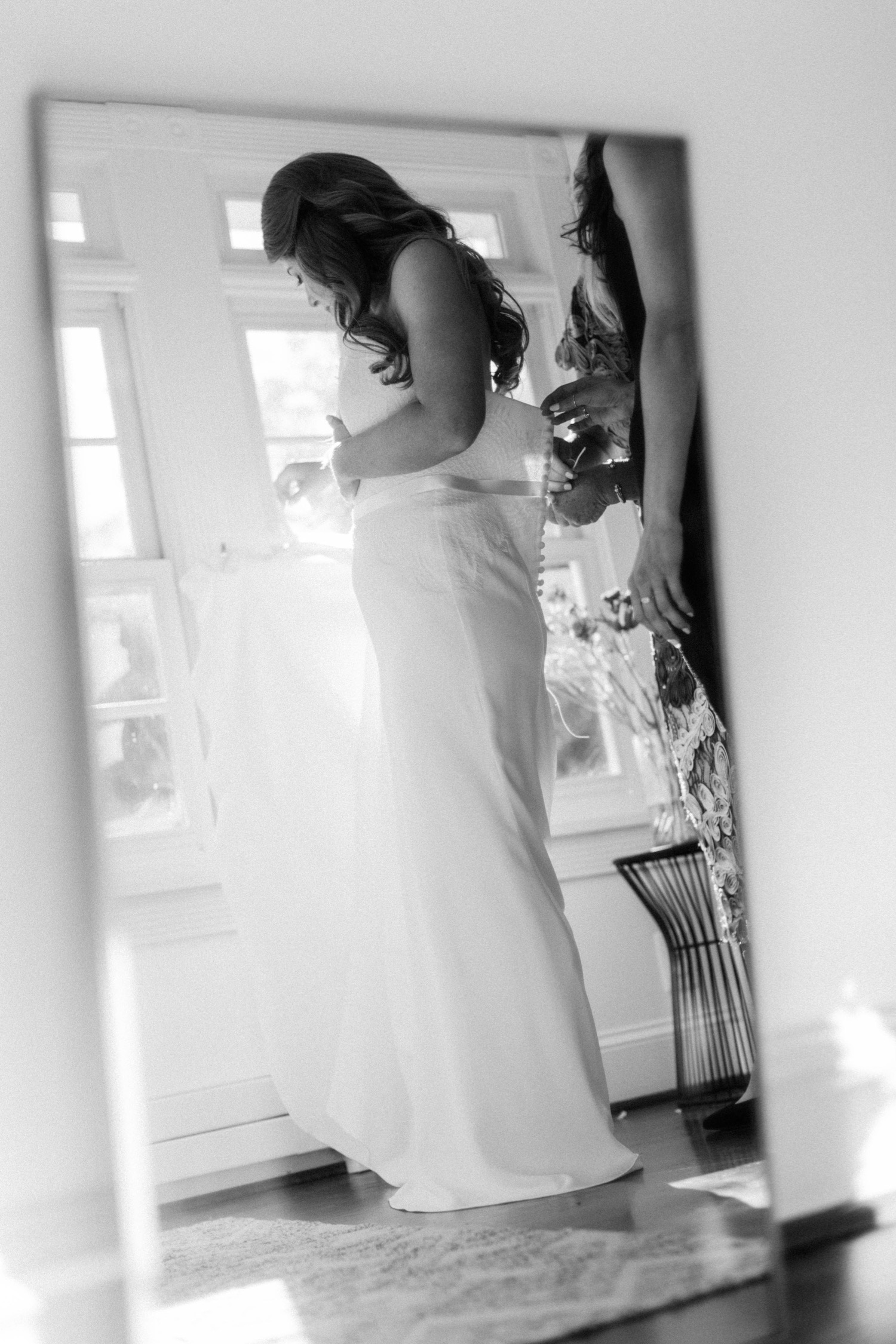 bride putting on wedding dress mirror reflection