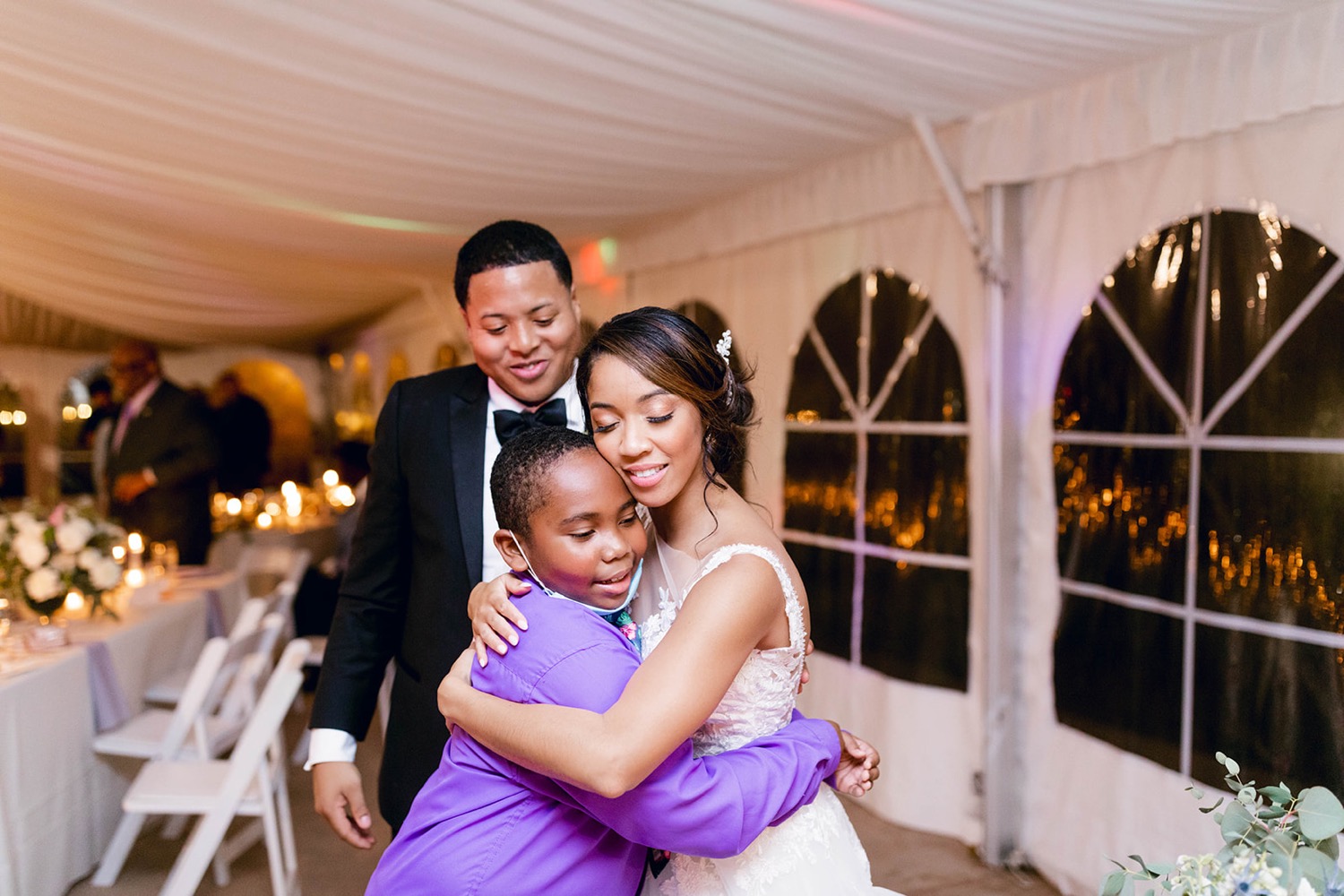 bride hugging young wedding guest reception
