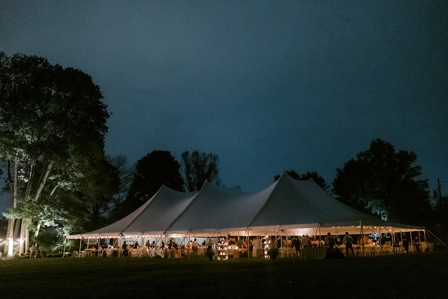 wedding tent lit up at night in the dark at dreamy backyard wedding