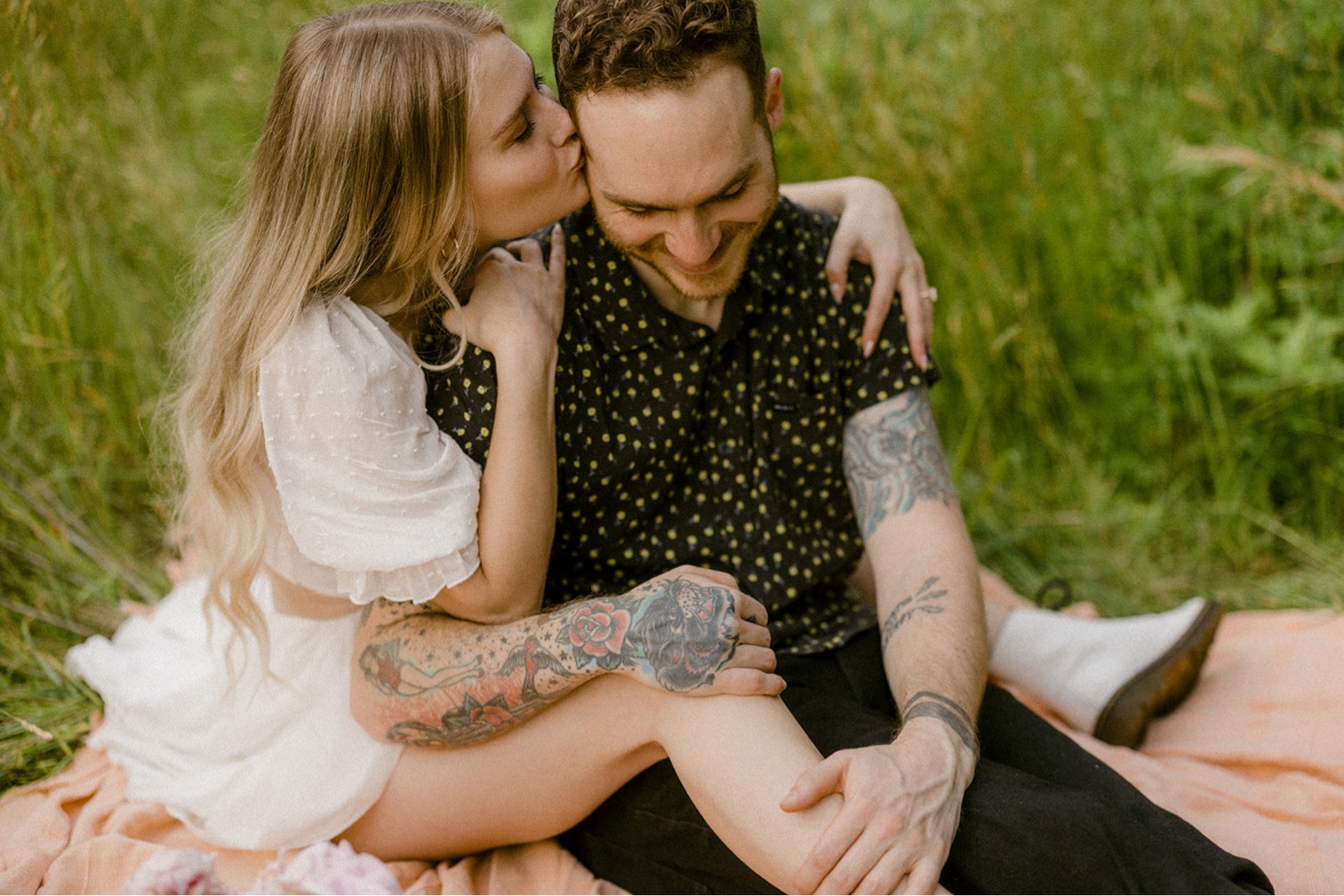 couple kissing picnic in field bohemian engagement session