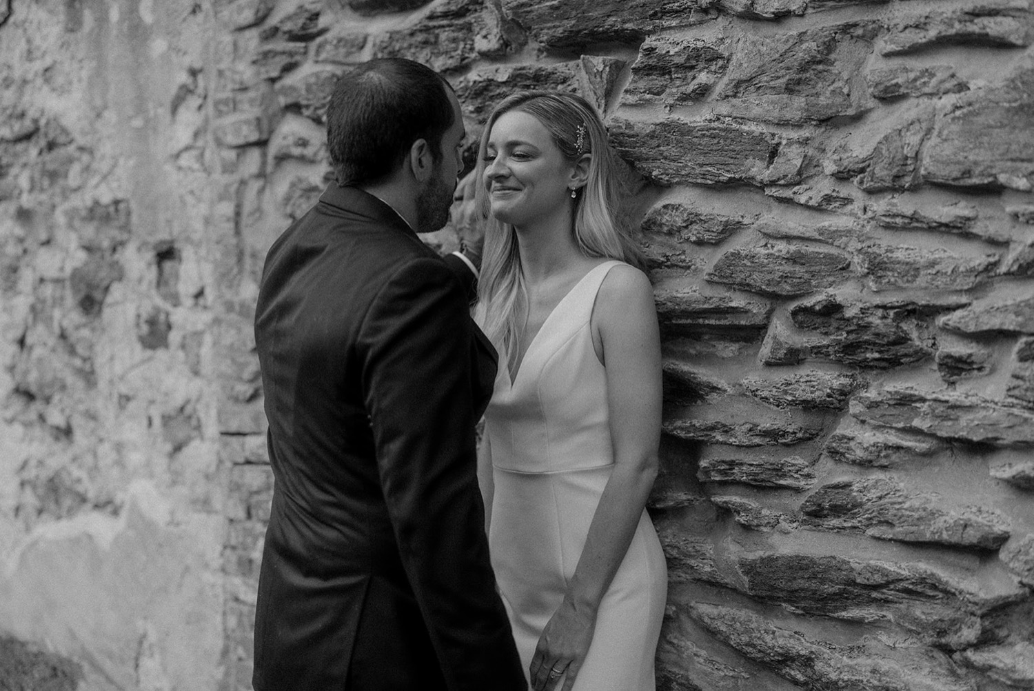 bride and groom intimate moment against stone wall the old mill wedding
