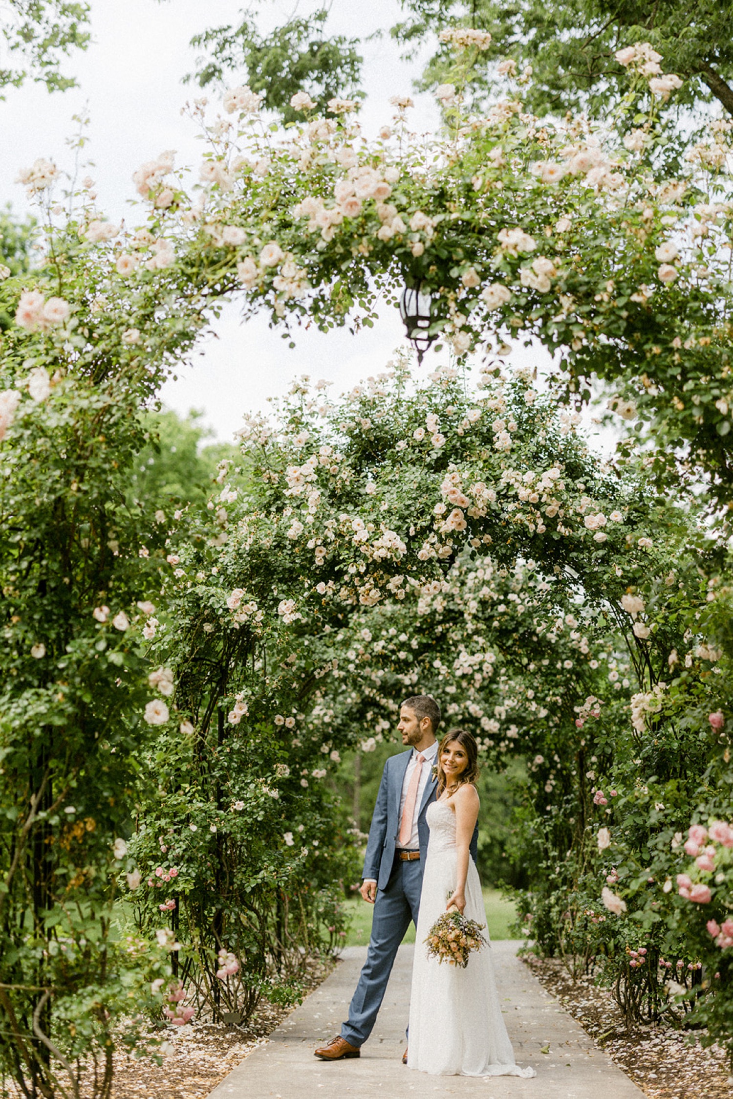 couple standing under rose arches moonstone manor wedding session