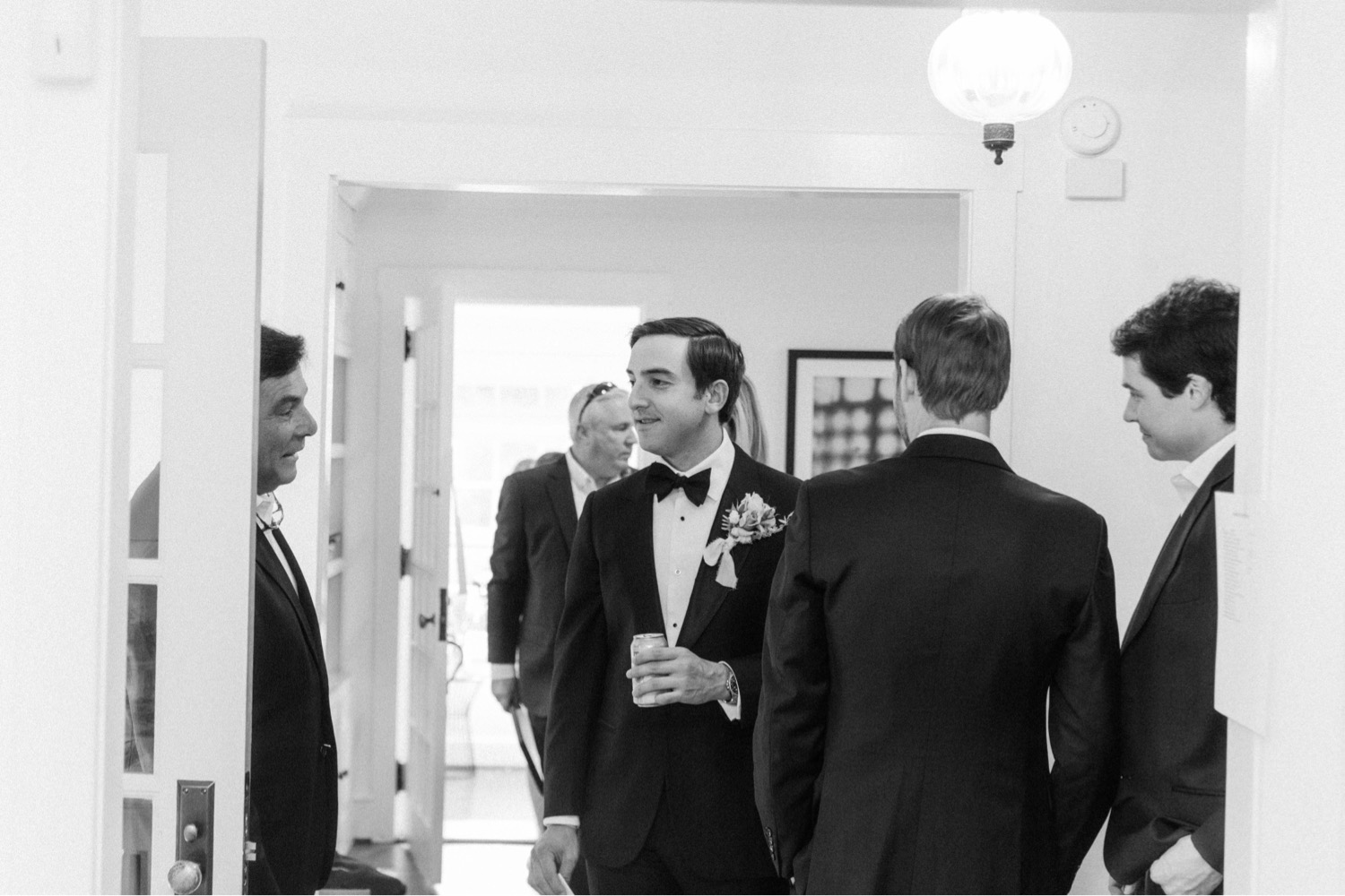 groom greeting wedding guests in house