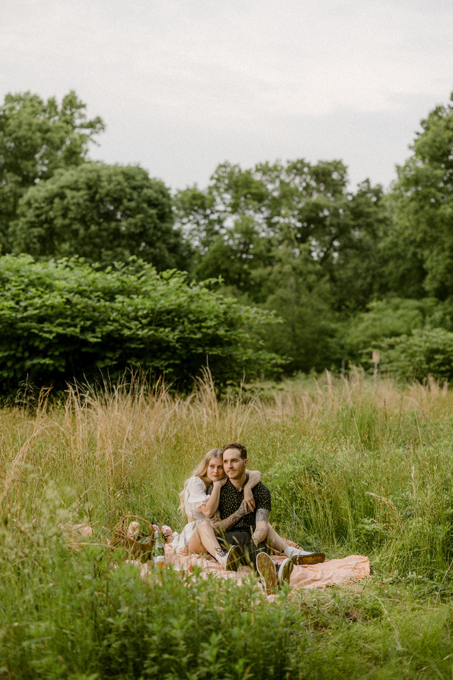 couple in field whimsical picnic bohemian engagement session