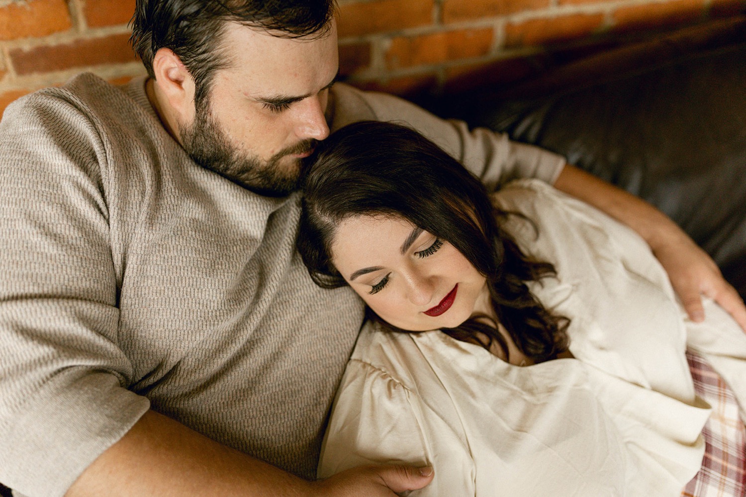 couple cuddling on couch romantic engagement session