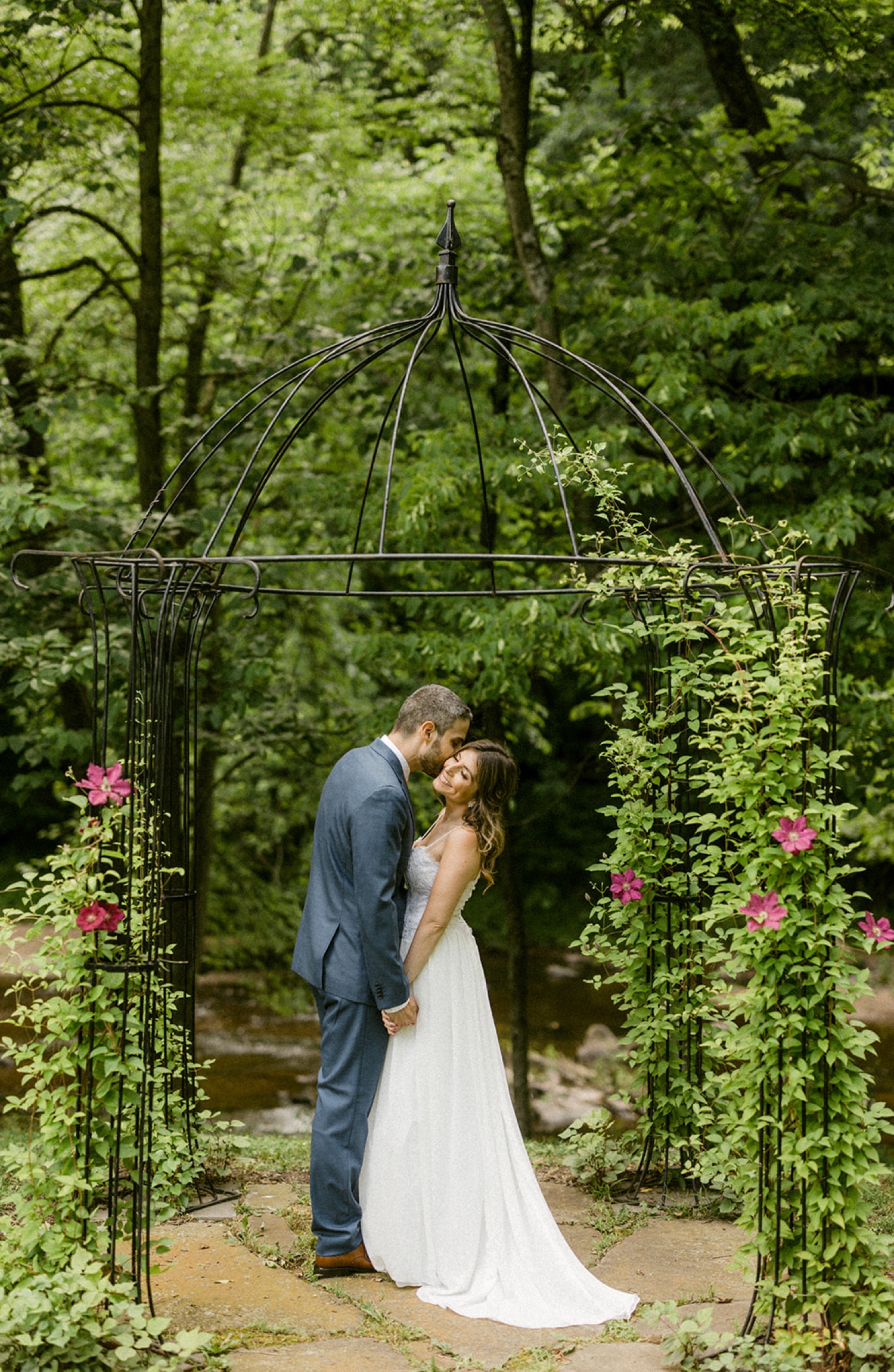 couple kissing under rose dome moonstone manor wedding session