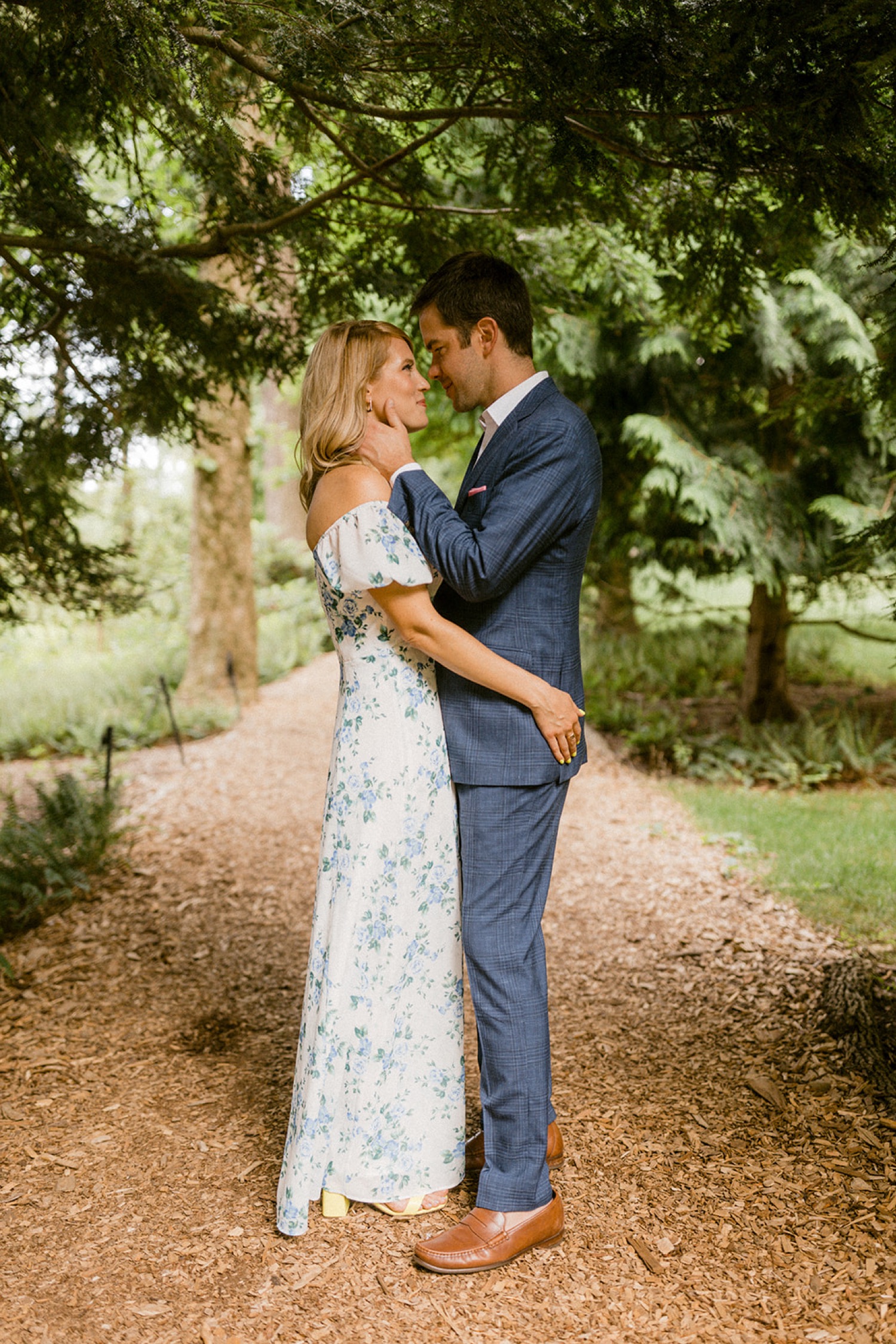 couple kissing under tree canopy at longwood gardens engagement session