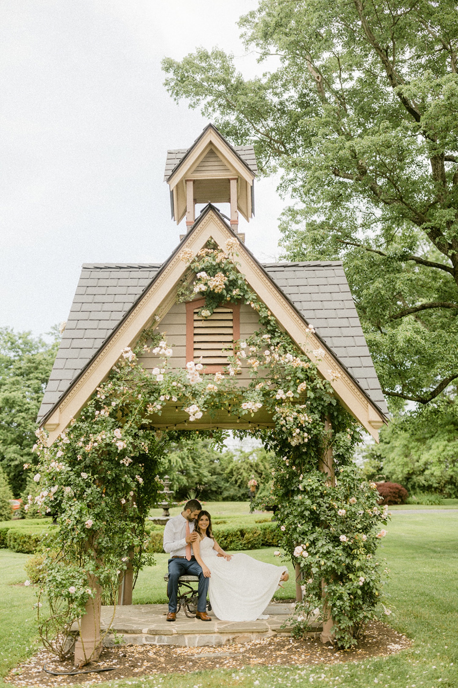 couple under structure with roses at moonstone manor wedding session