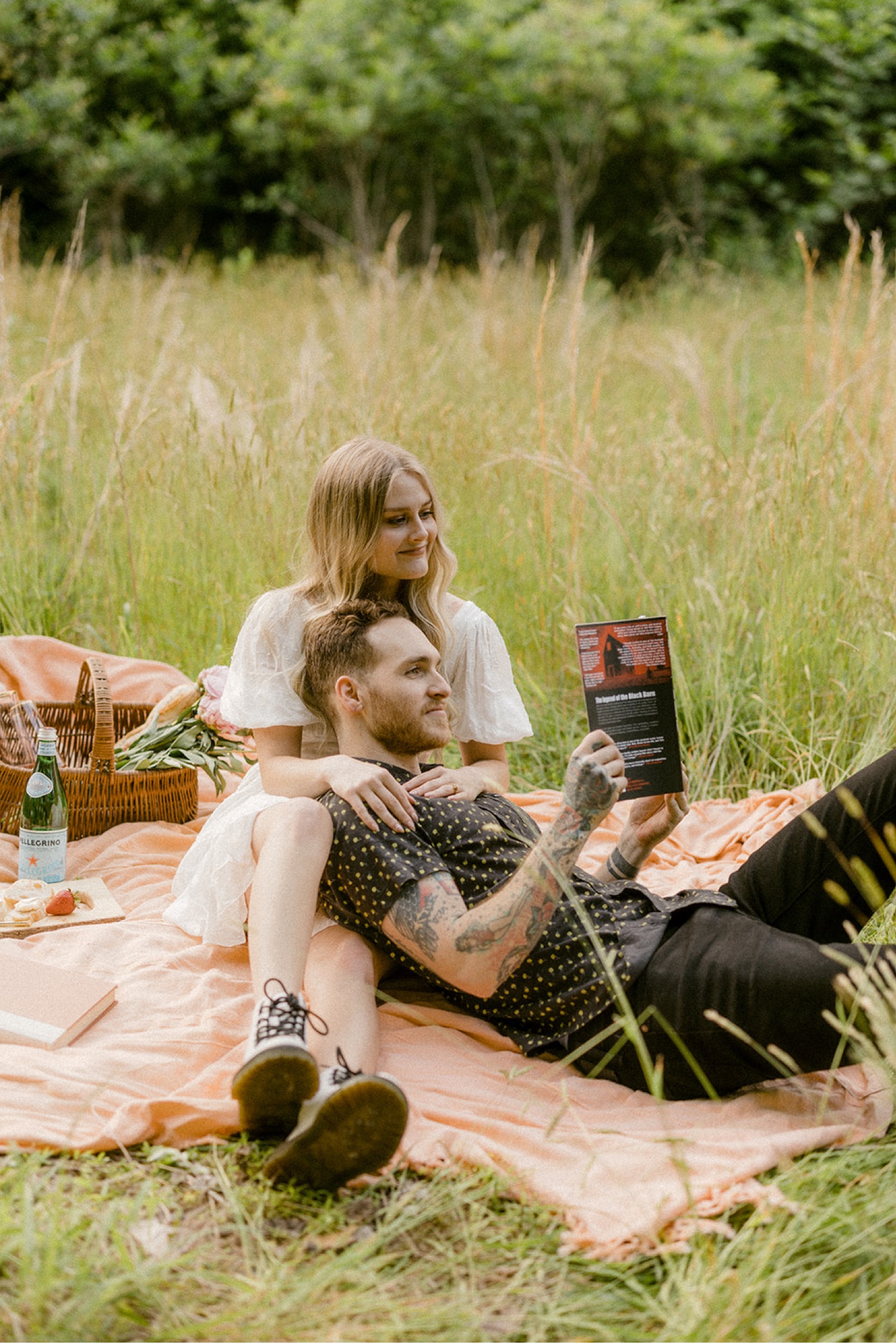 couple sitting on picnic blanket reading book andorra meadows