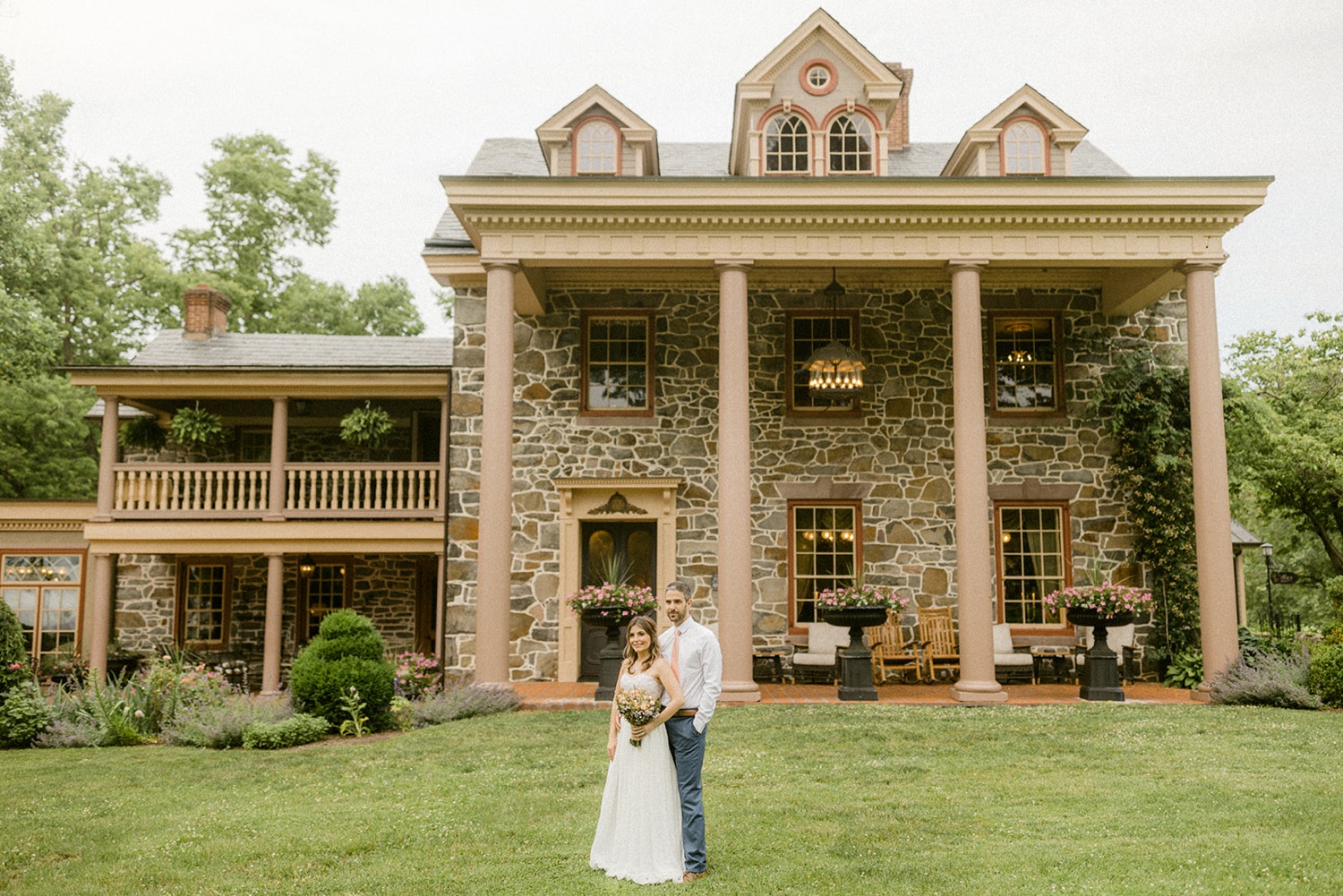 couple standing in front of moonstone manor wedding session