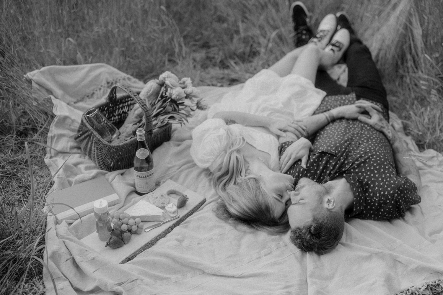 couple laying on blanket kissing picnic outdoor engagement session