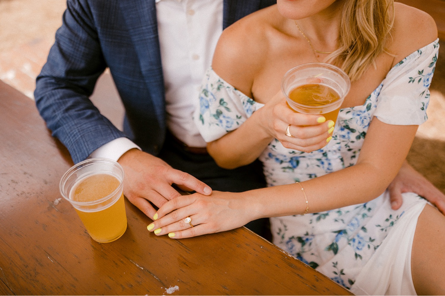couple holding hands drinking beer engagement session