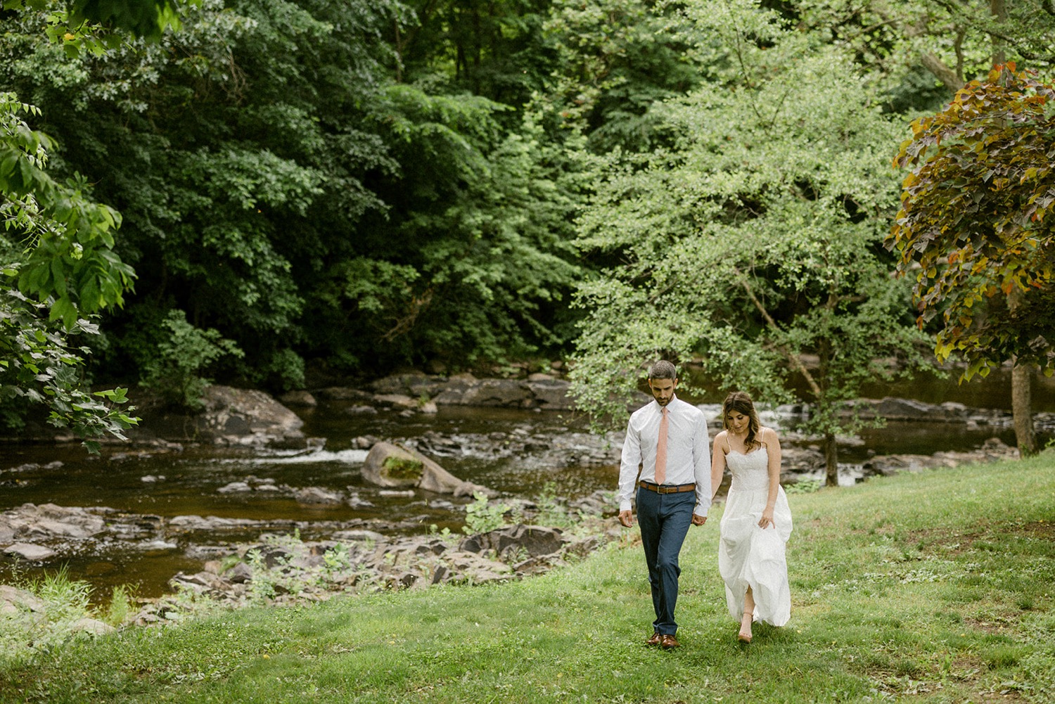 couple walking near river in forest Whimsical Moonstone Manor Wedding Session