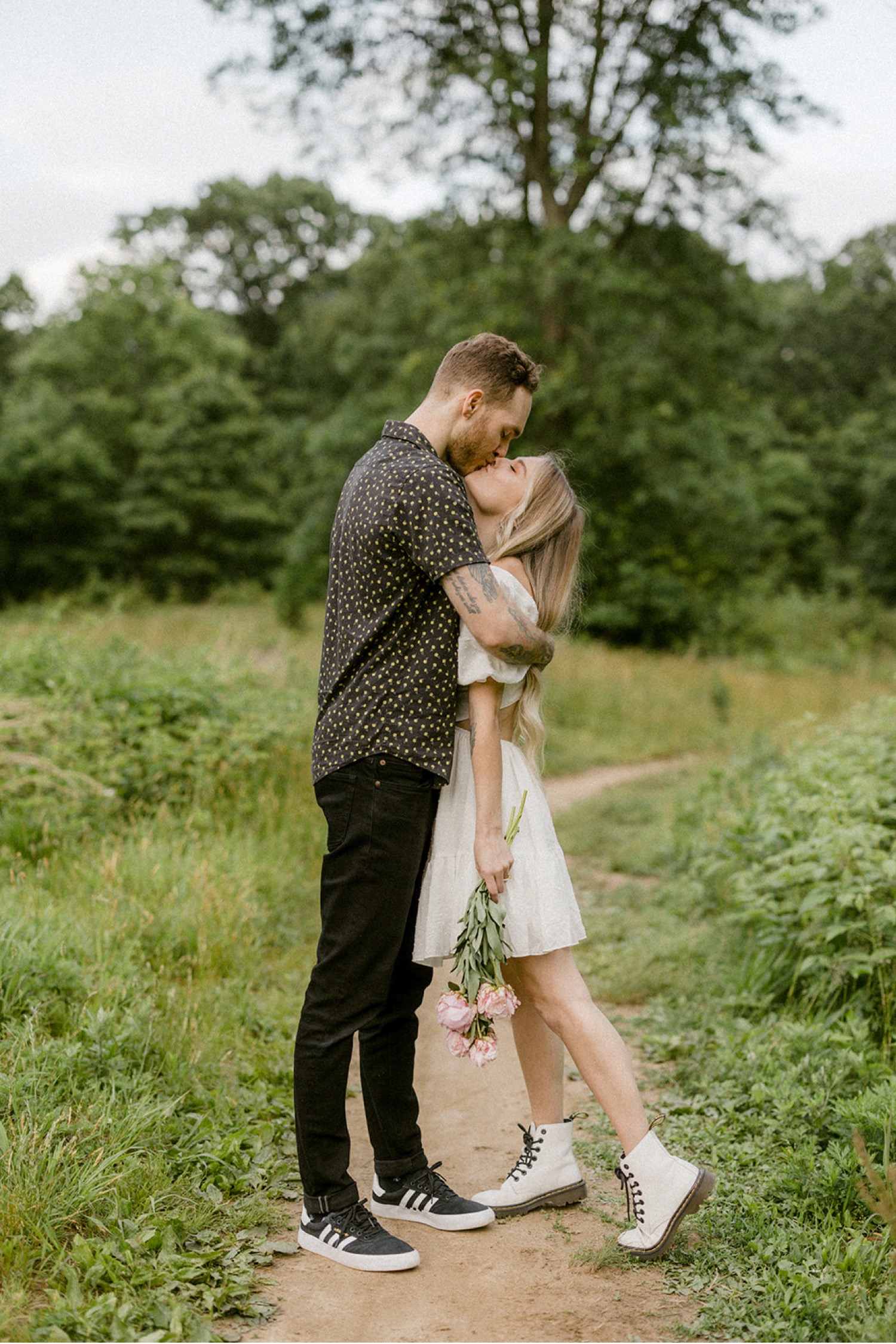 couple kissing on outdoor trail bohemian chic engagement session
