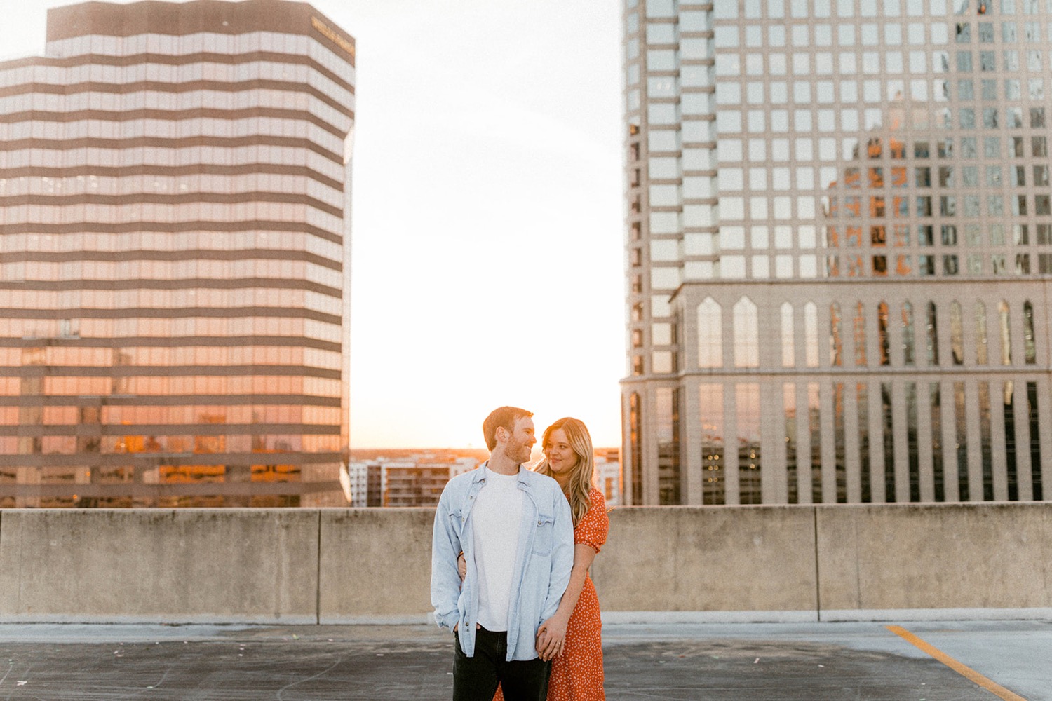 couple on parking garage rooftop at sunset