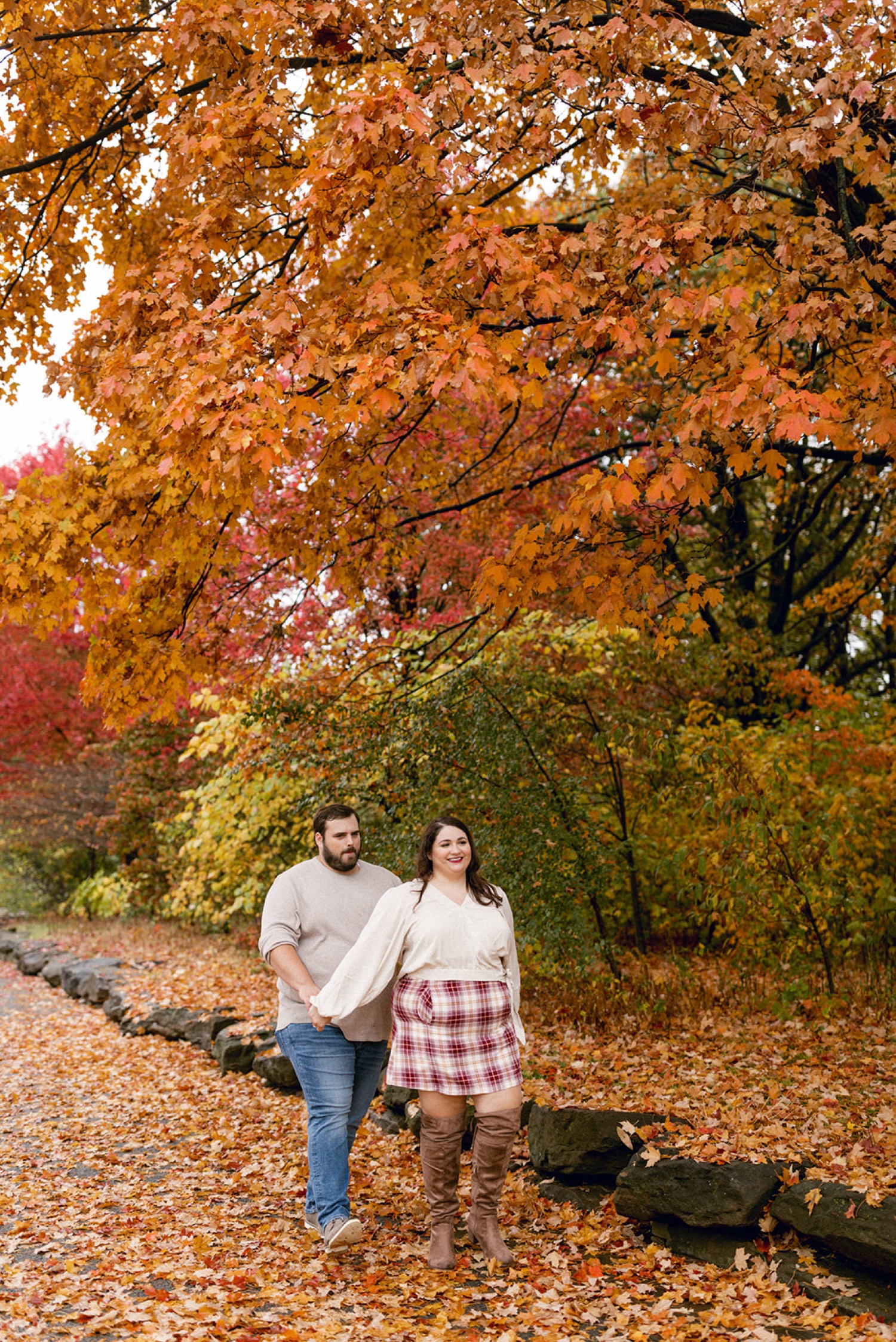 couple walking orange fall leaves
