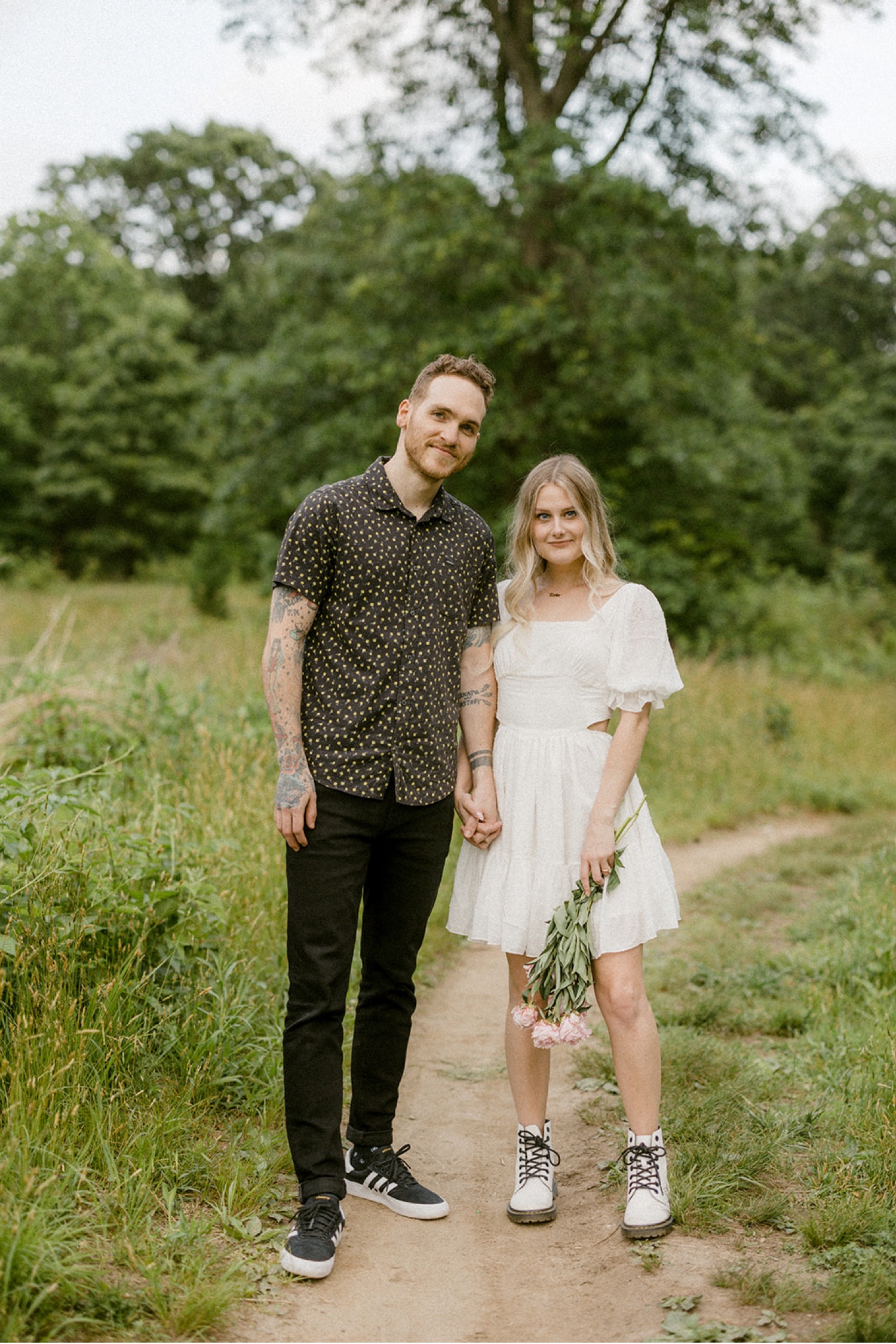 couple holding hands flower bouquet outdoor engagement session