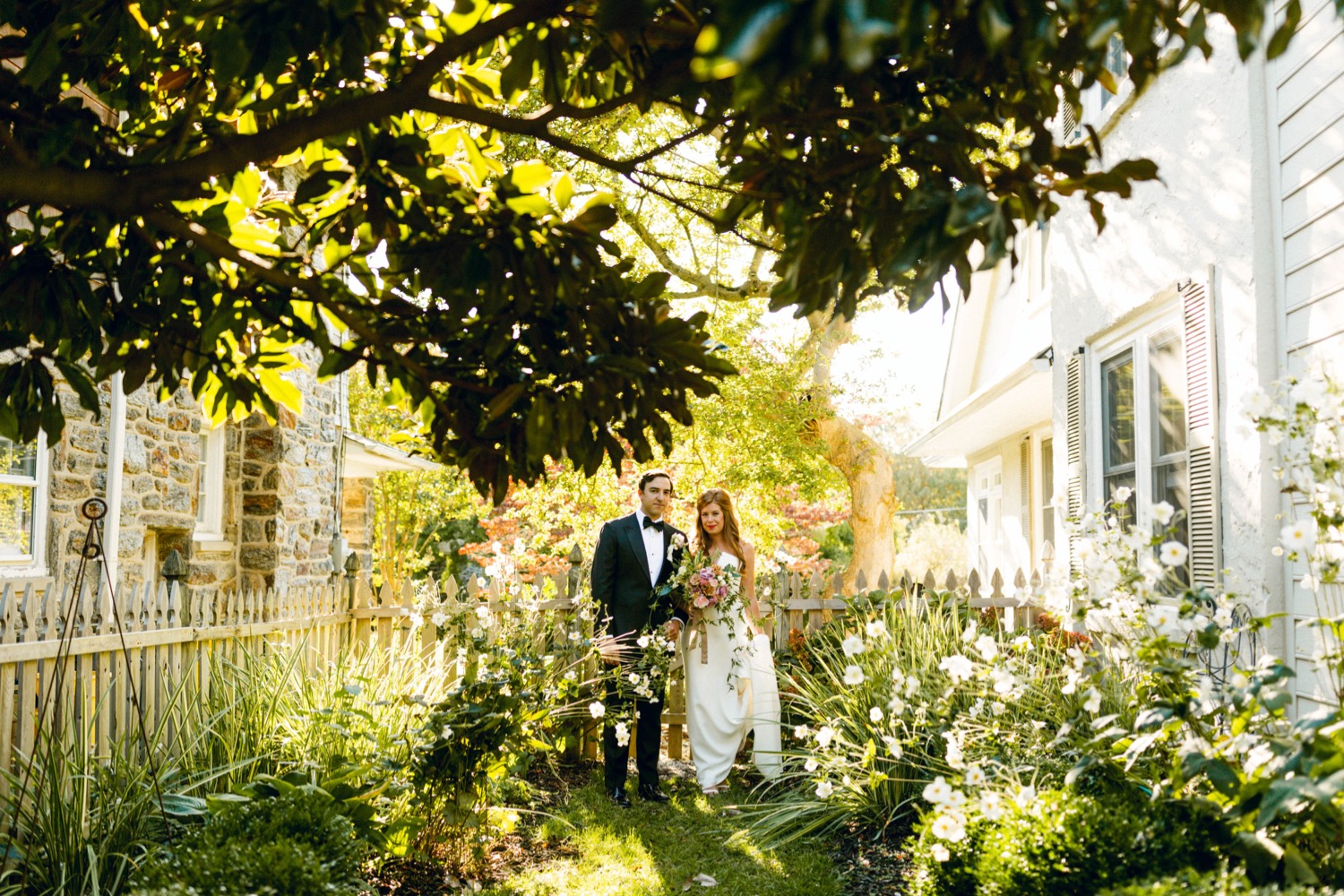 bride and groom under tree luxurious backyard wedding