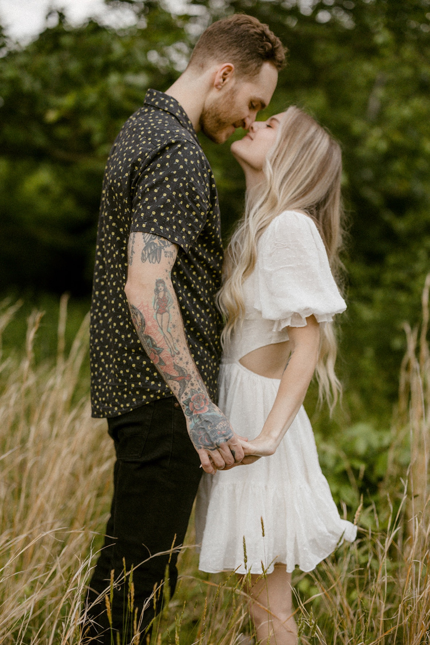 couple kissing in field boho chic engagement session