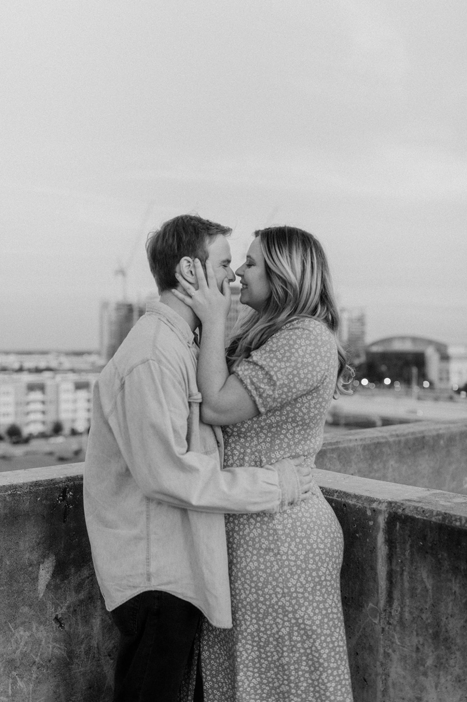 couple kissing on rooftop holding face