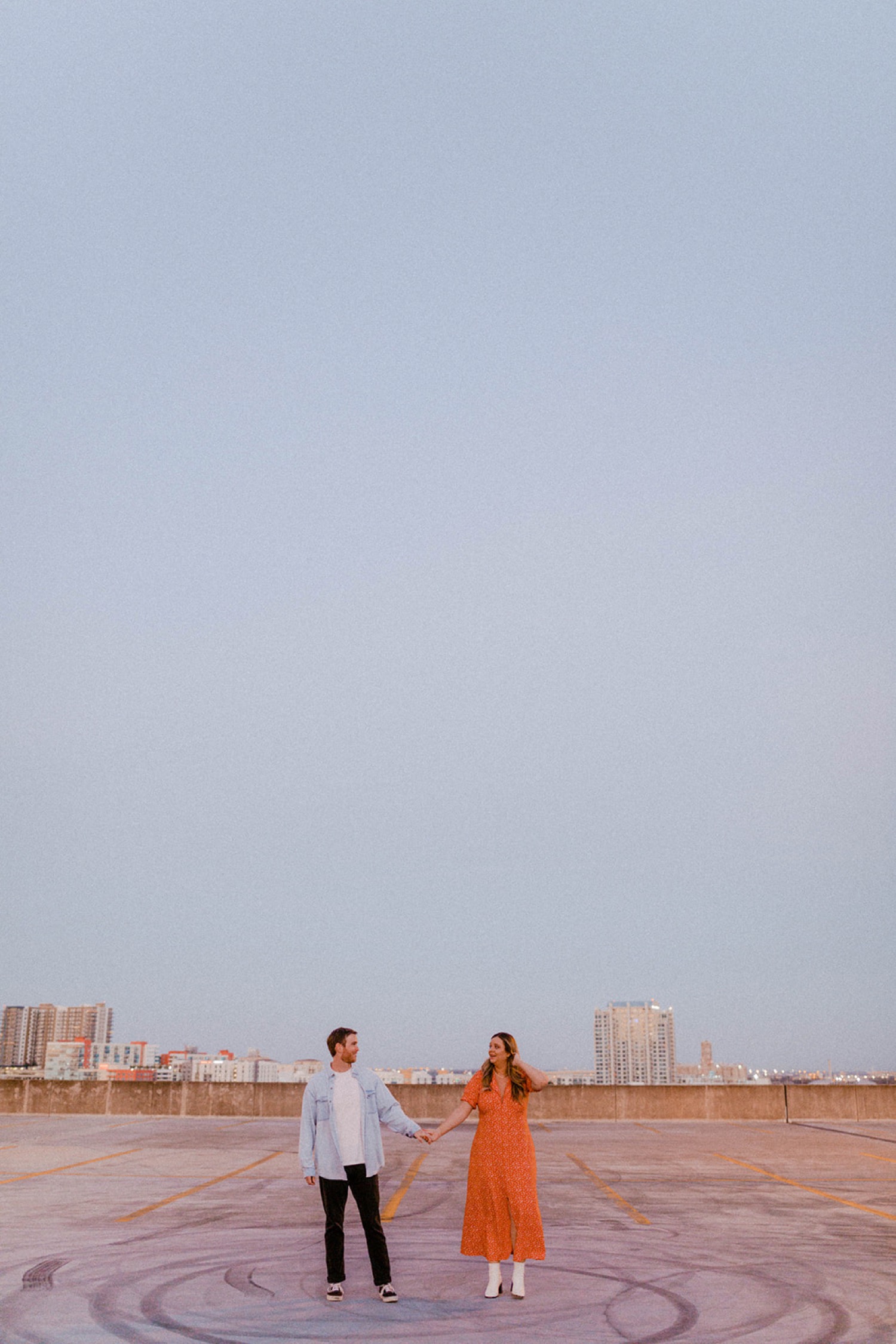 couple standing on rooftop at dusk dreamy engagement session