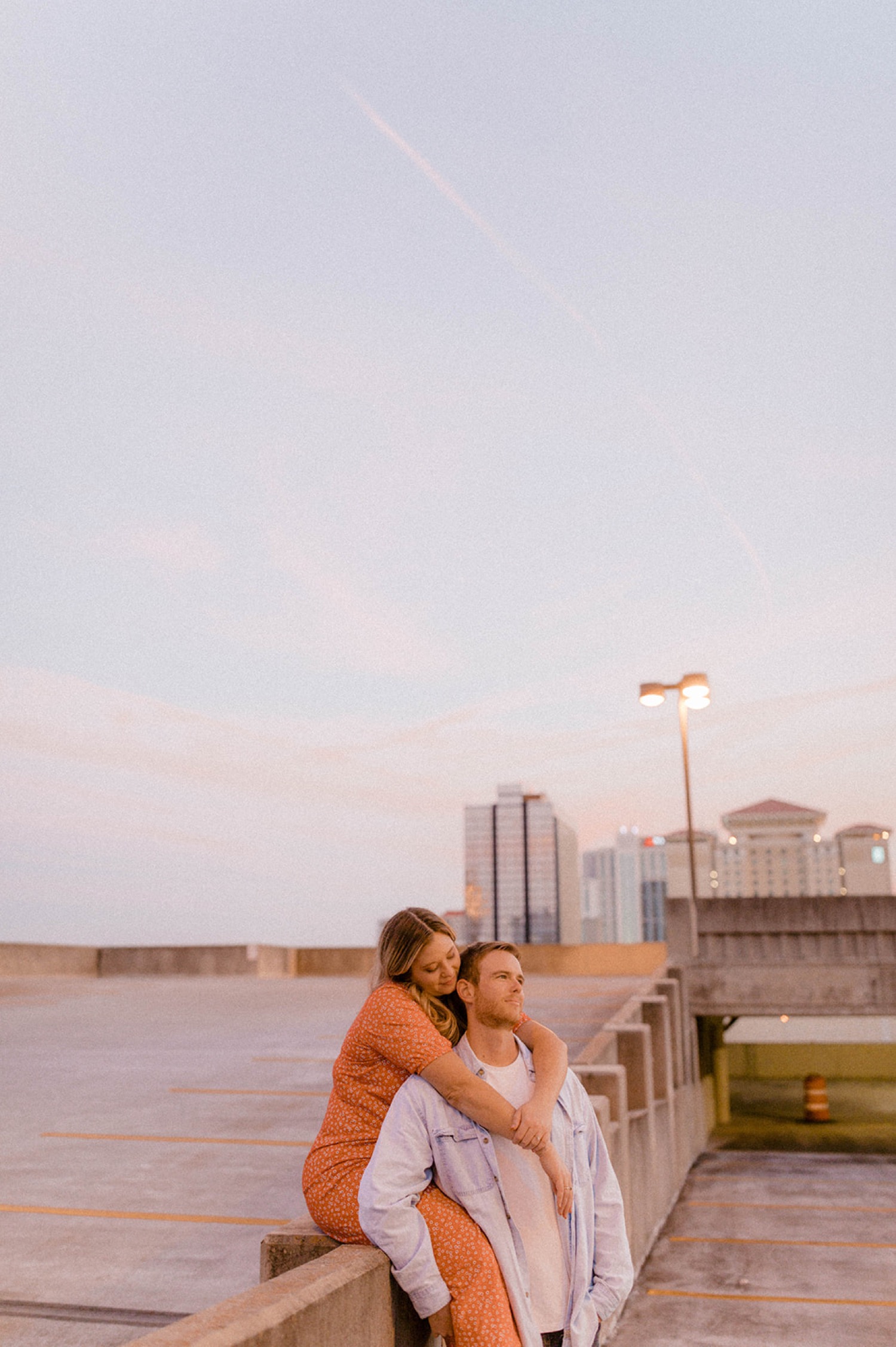 couple embracing on parking garage at sunset dreamy engagement session