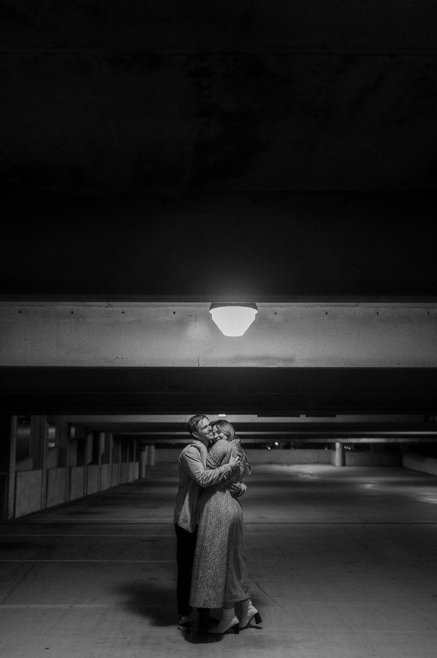 couple hugging in parking garage black and white