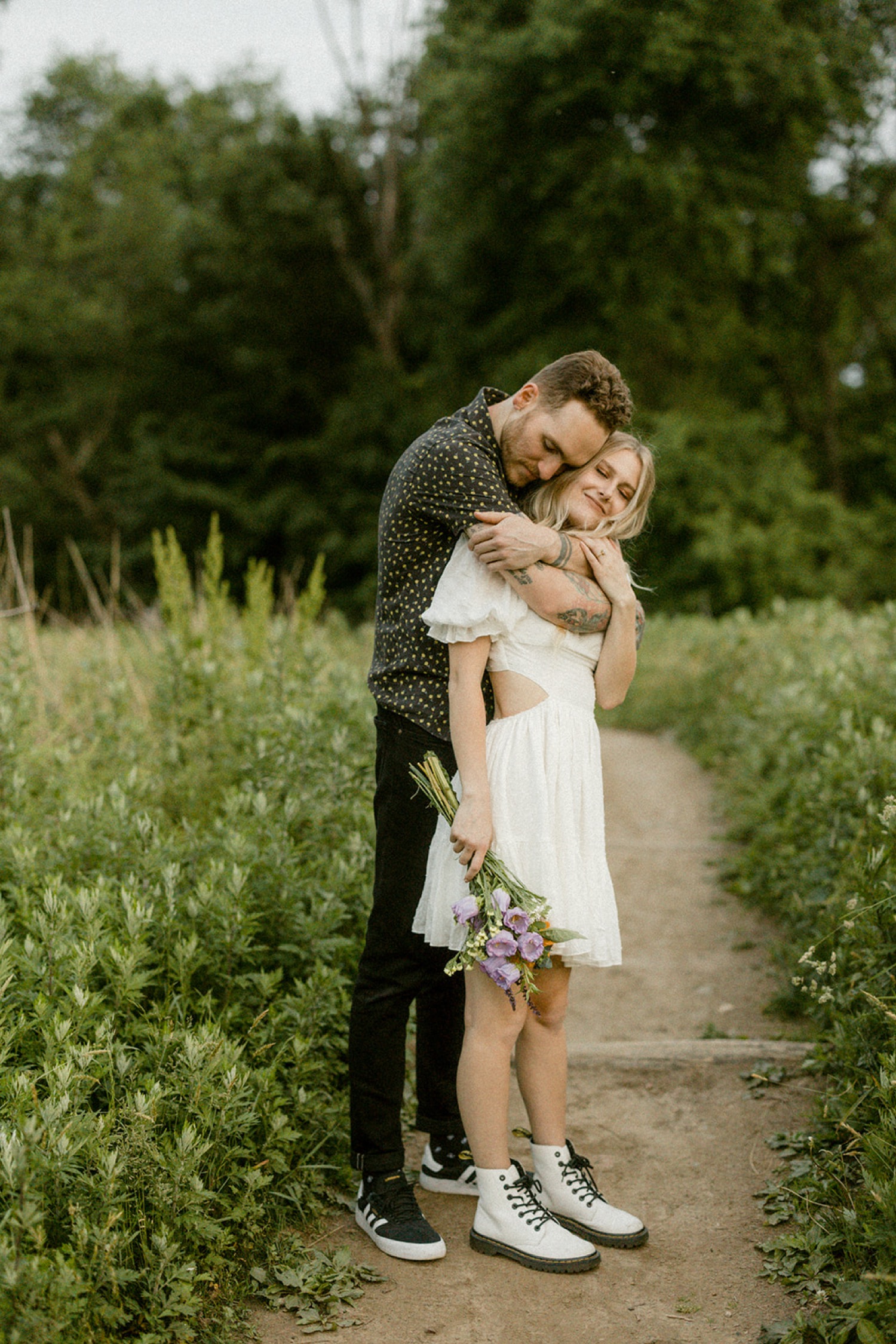 couple hugging from behind on trail whimsical engagement session