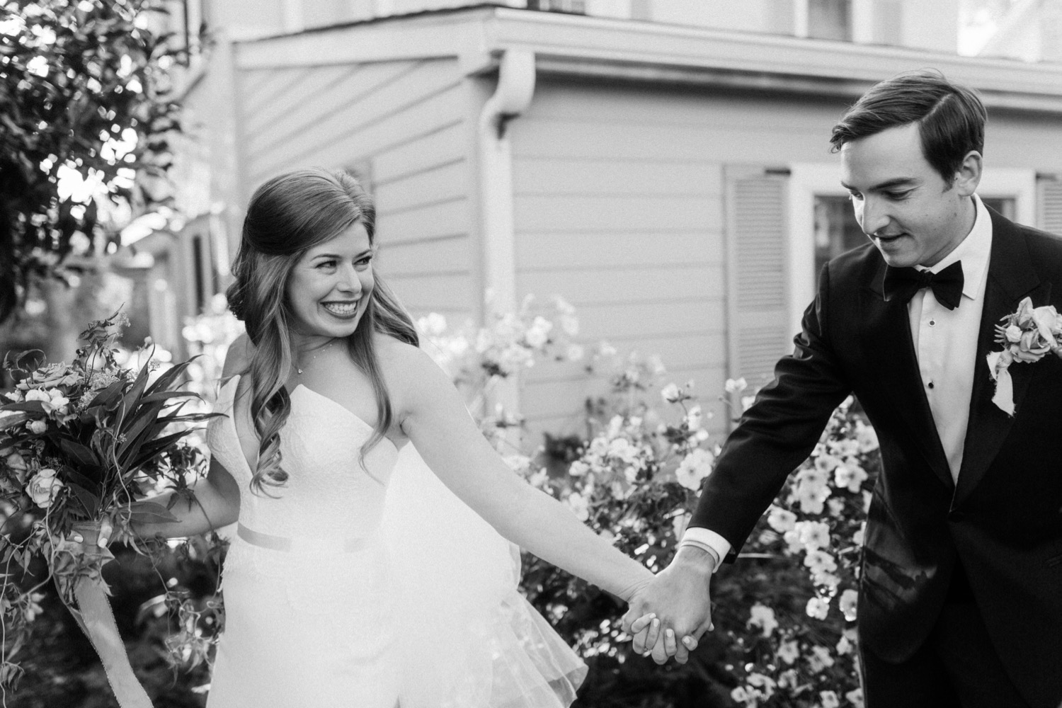 bride and groom holding hands smiling walking out of backyard wedding ceremony
