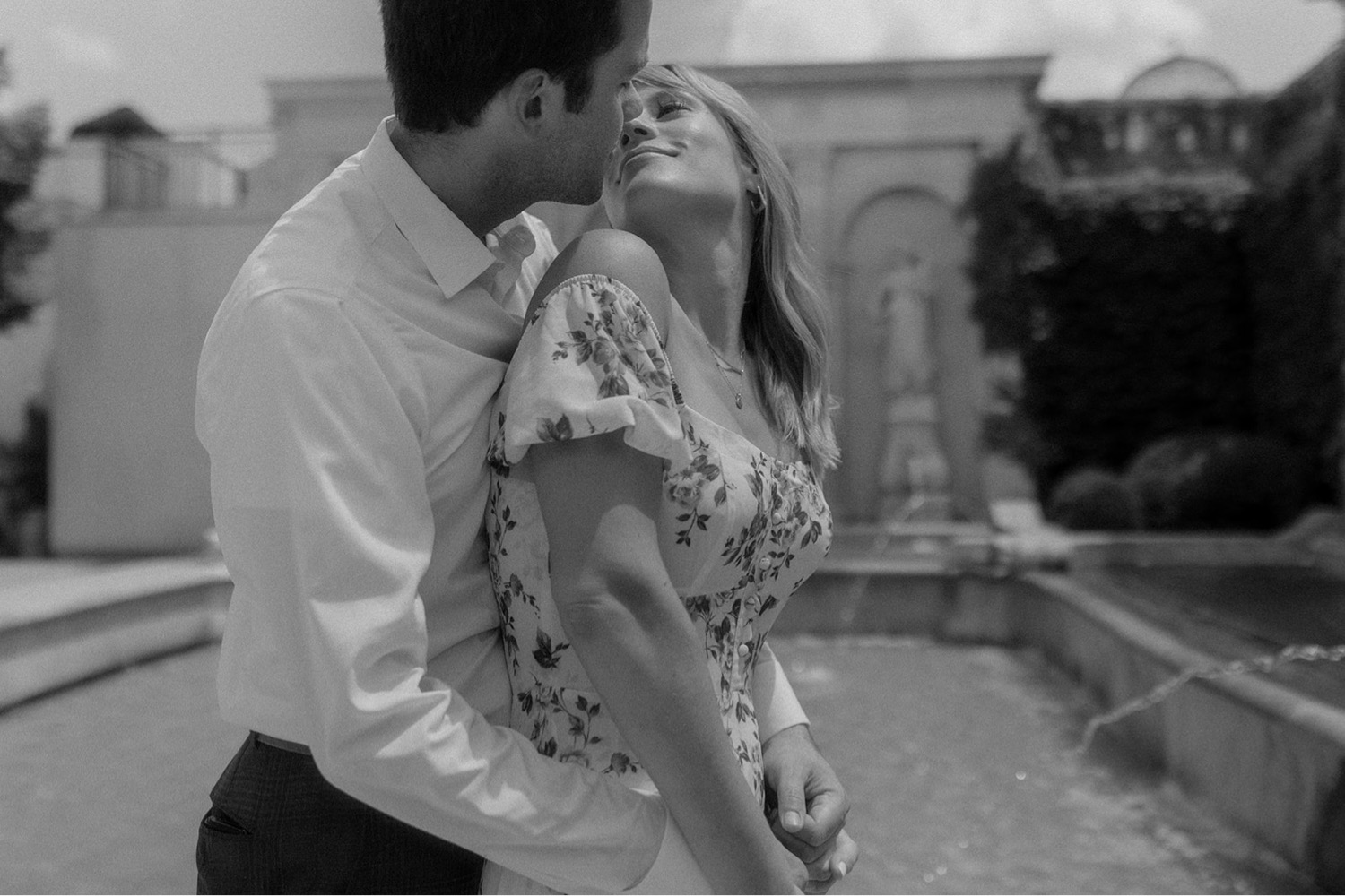 black and white intimate couple kissing on water fountain engagement session
