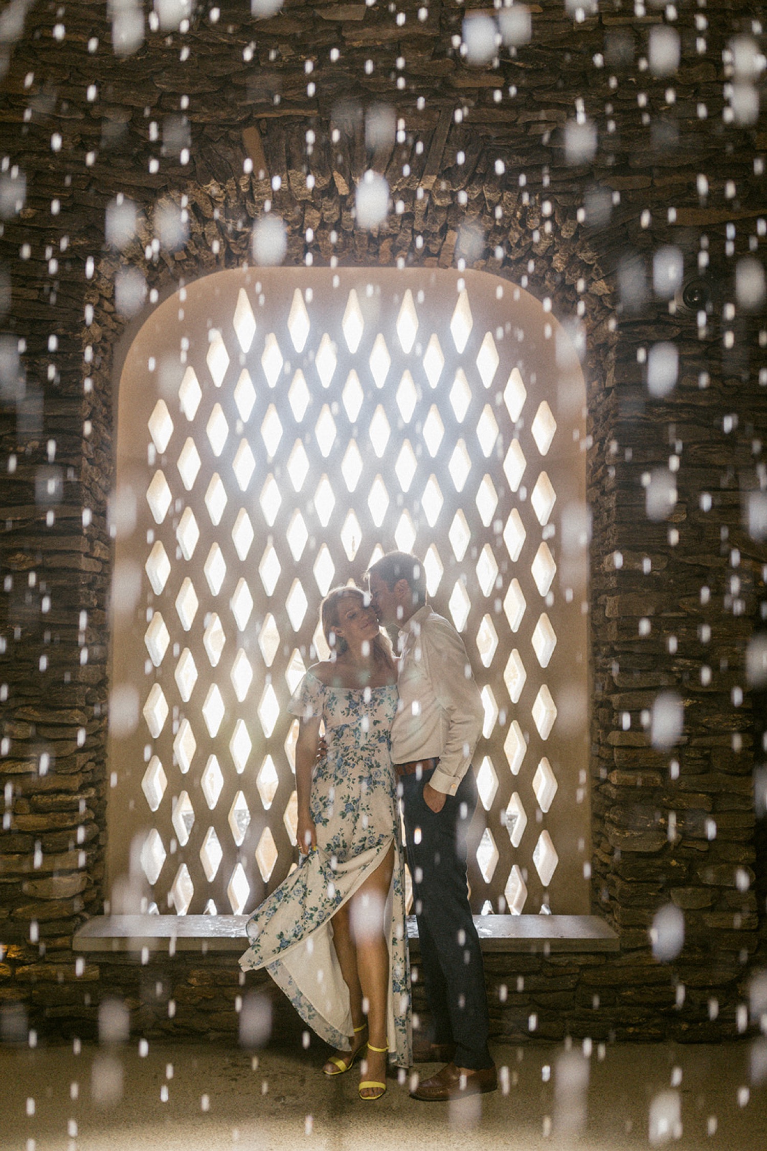 artistic couple kissing behind waterfall longwood gardens engagement session