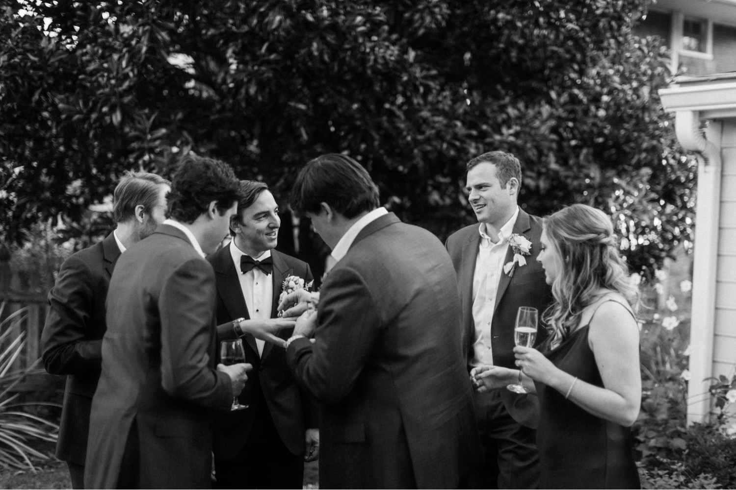 groom socializing cocktail hour luxurious backyard wedding
