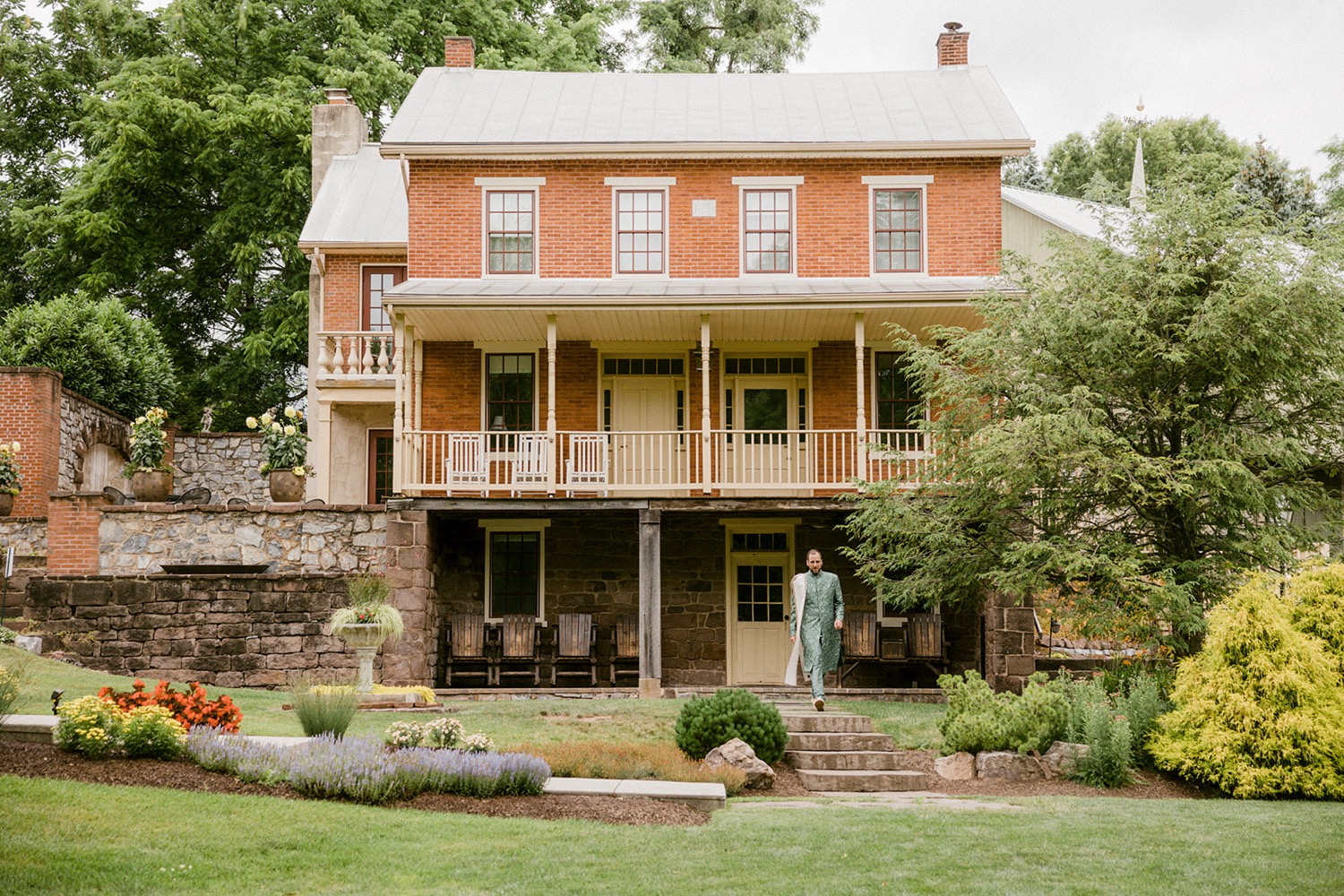 groom walking out of brick house Historic Acres of Hershey Wedding