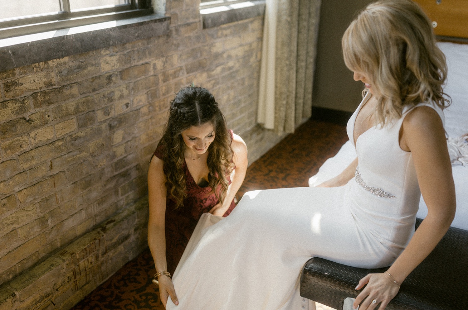 maid of honor putting on shoes for bride