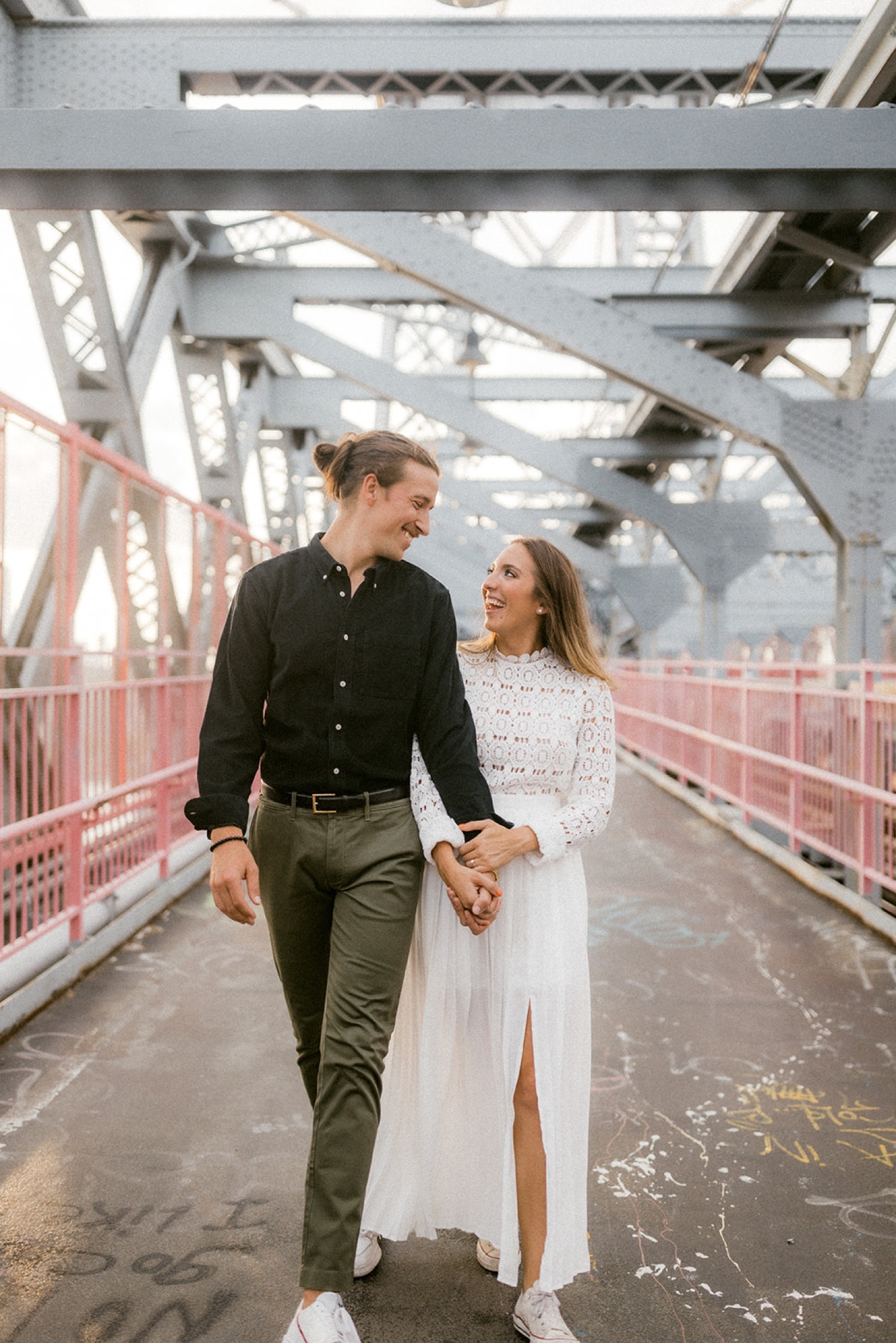 couple walking holding hands on bridge brooklyn engagement session