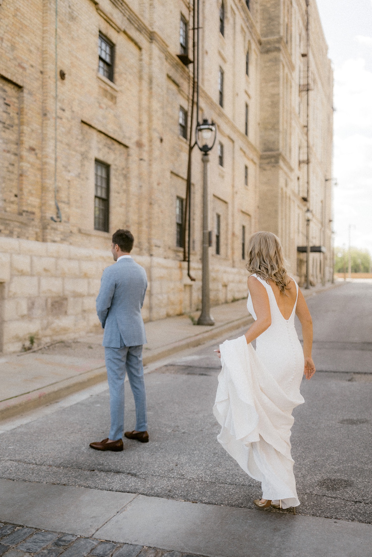 bride walking towards groom first look downtown Milwaukee