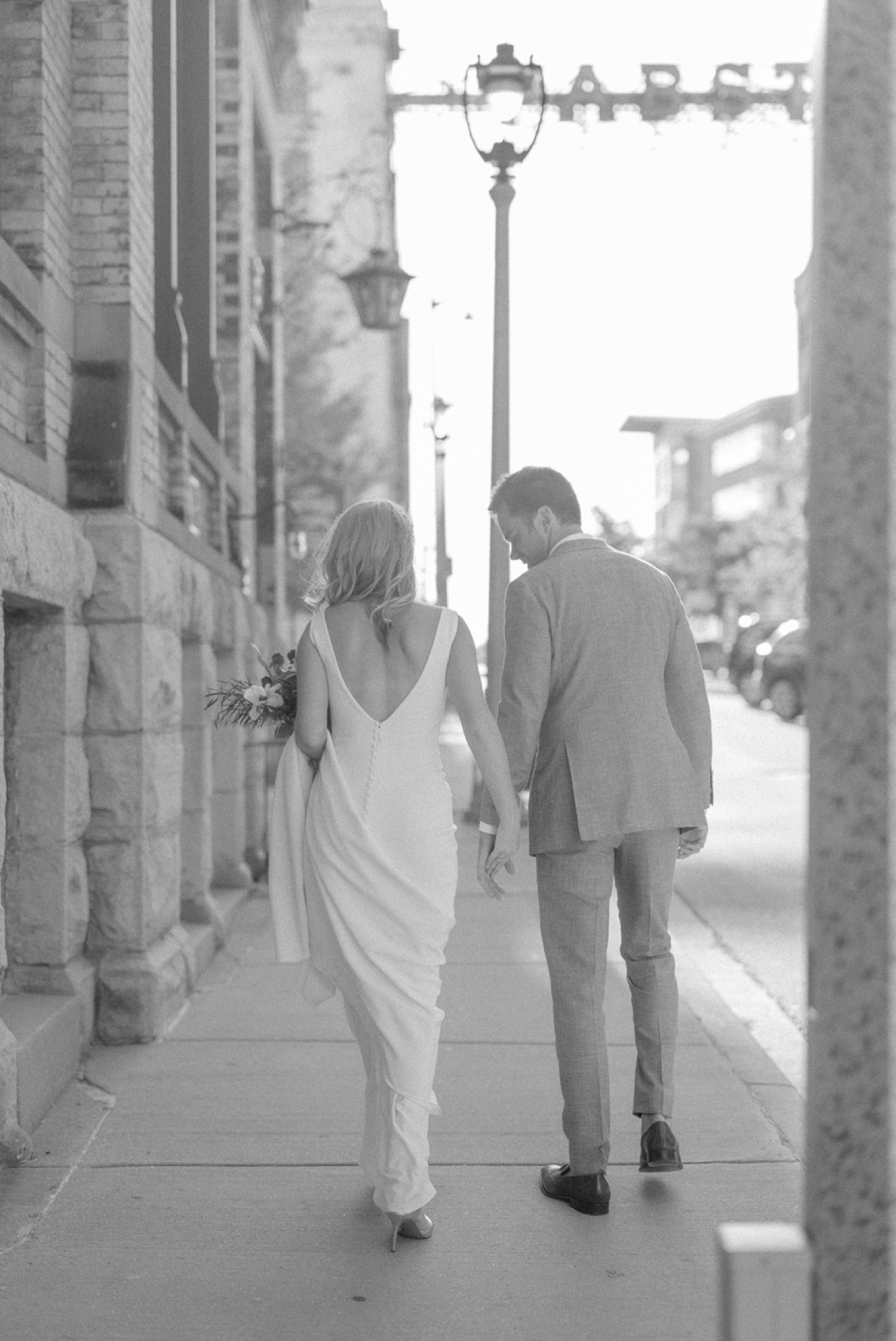 bride and groom holding hands walking outside