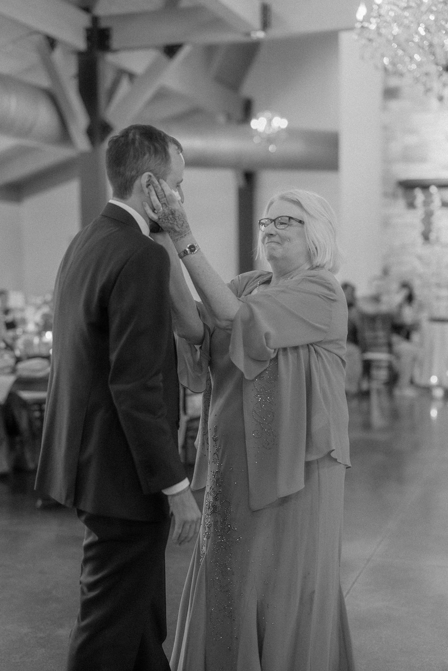 mom tugging grooms ears wedding reception