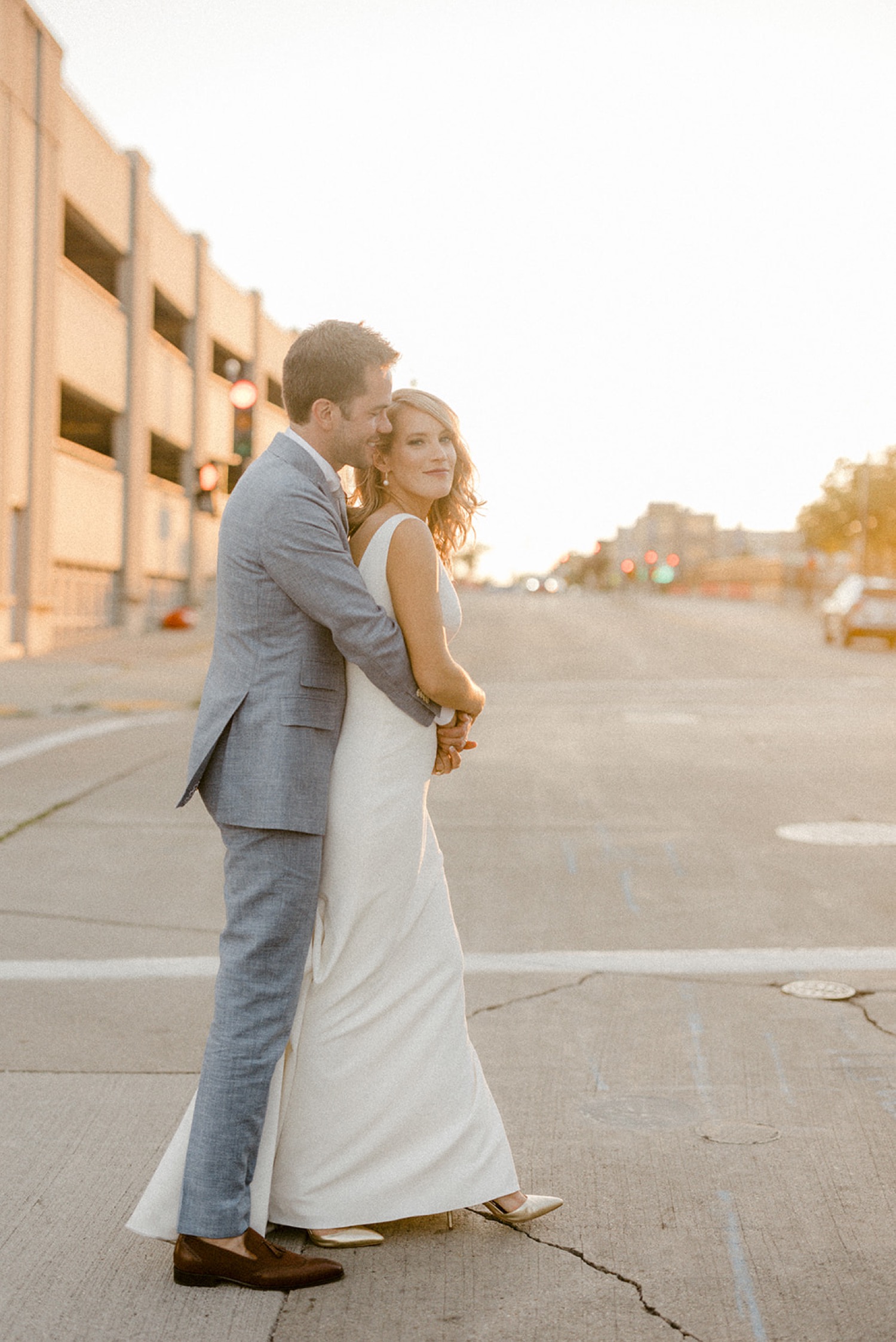 bride and groom walking across street crosswalk downtown Milwaukee