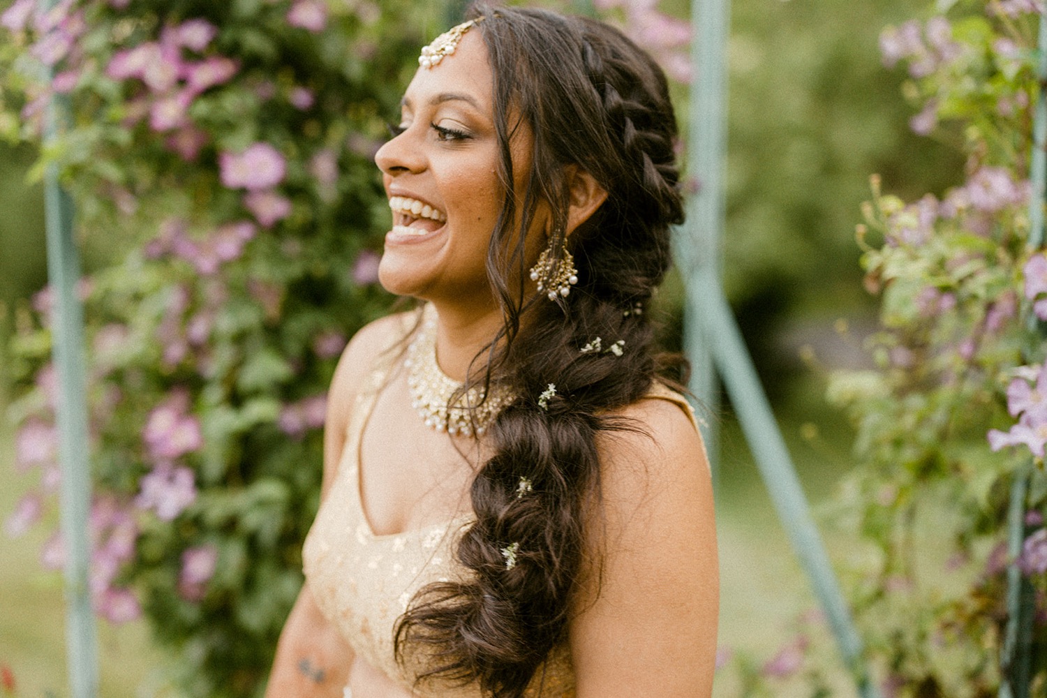 bride laughing flowers in hair braid