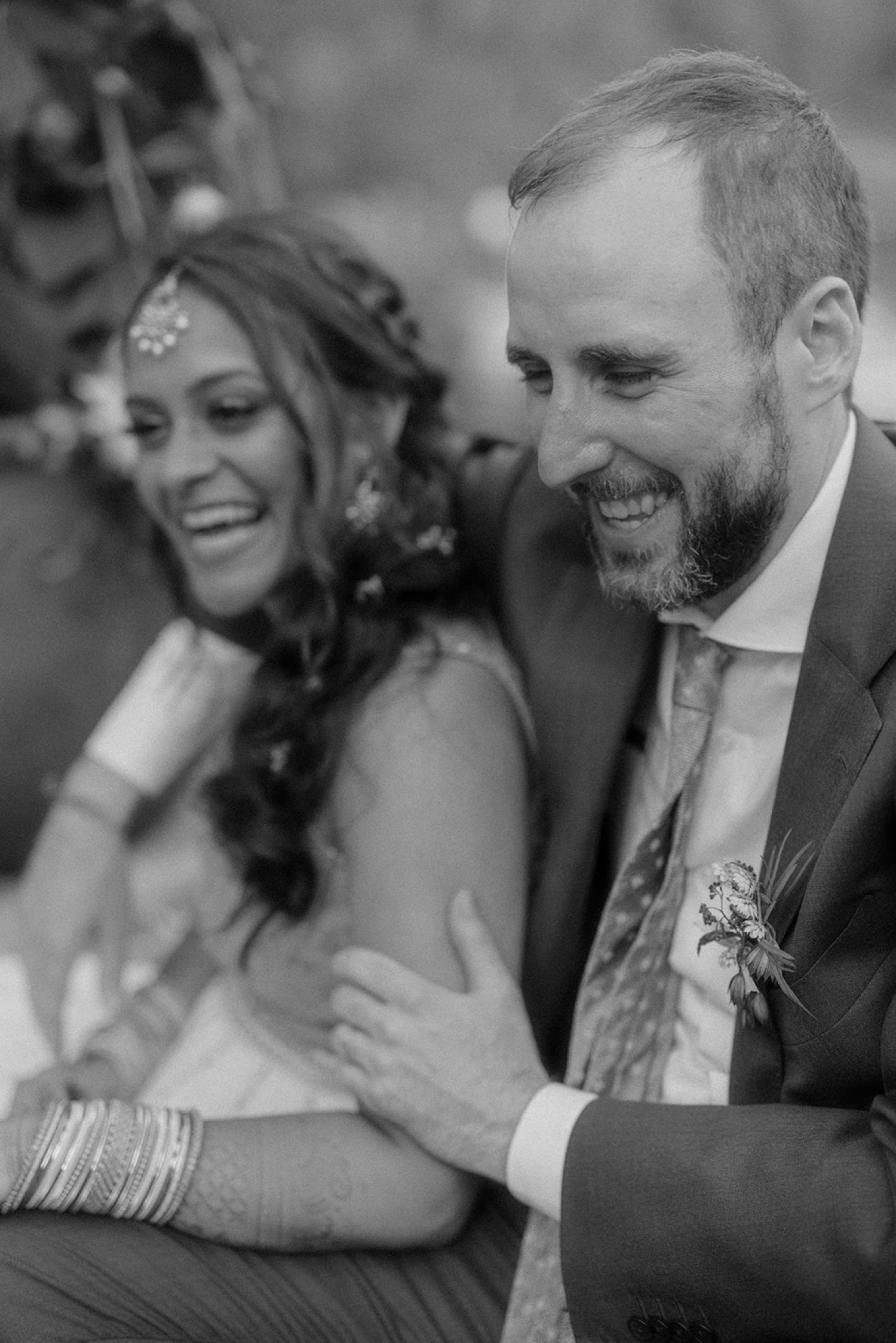 bride and groom arm around shoulder laughing wedding portrait