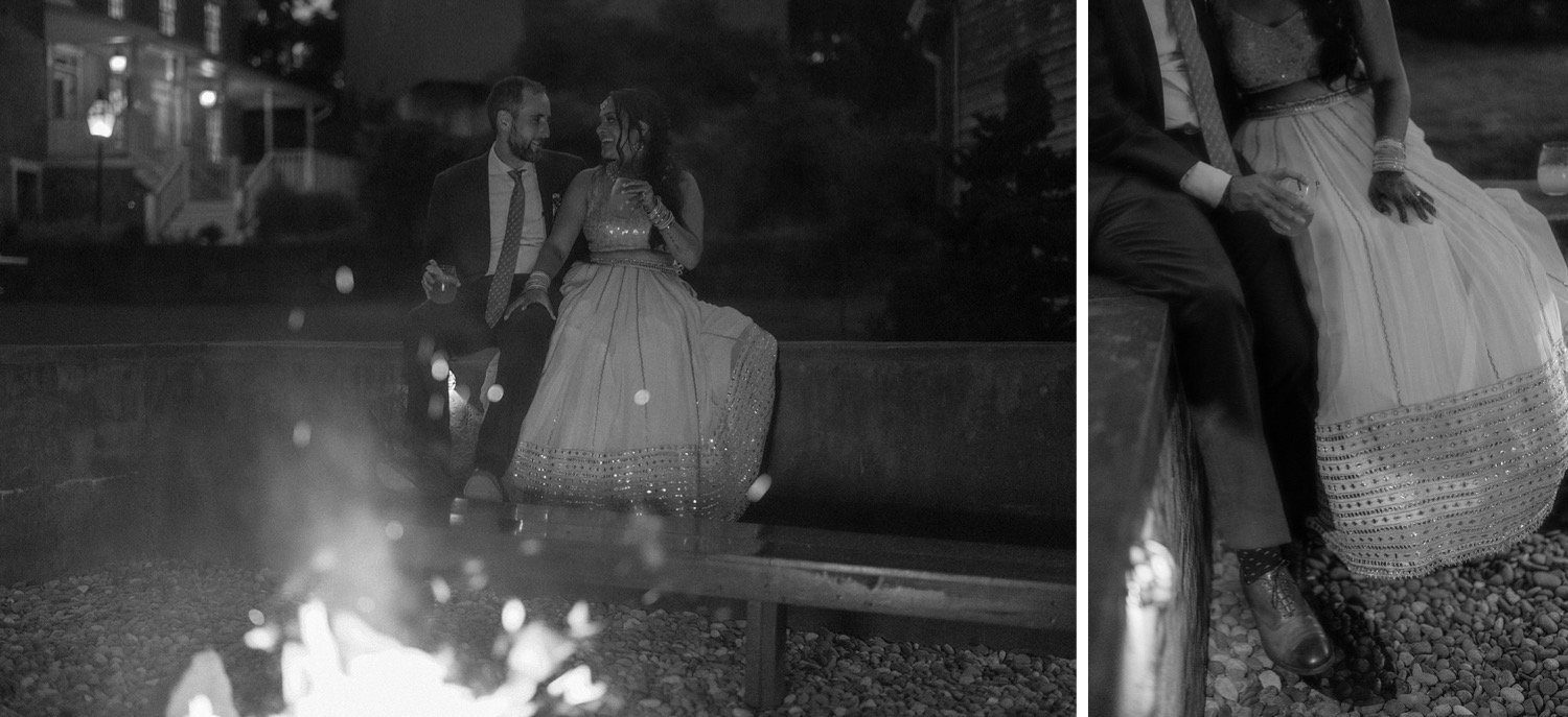 bride and groom sitting by fire wedding reception