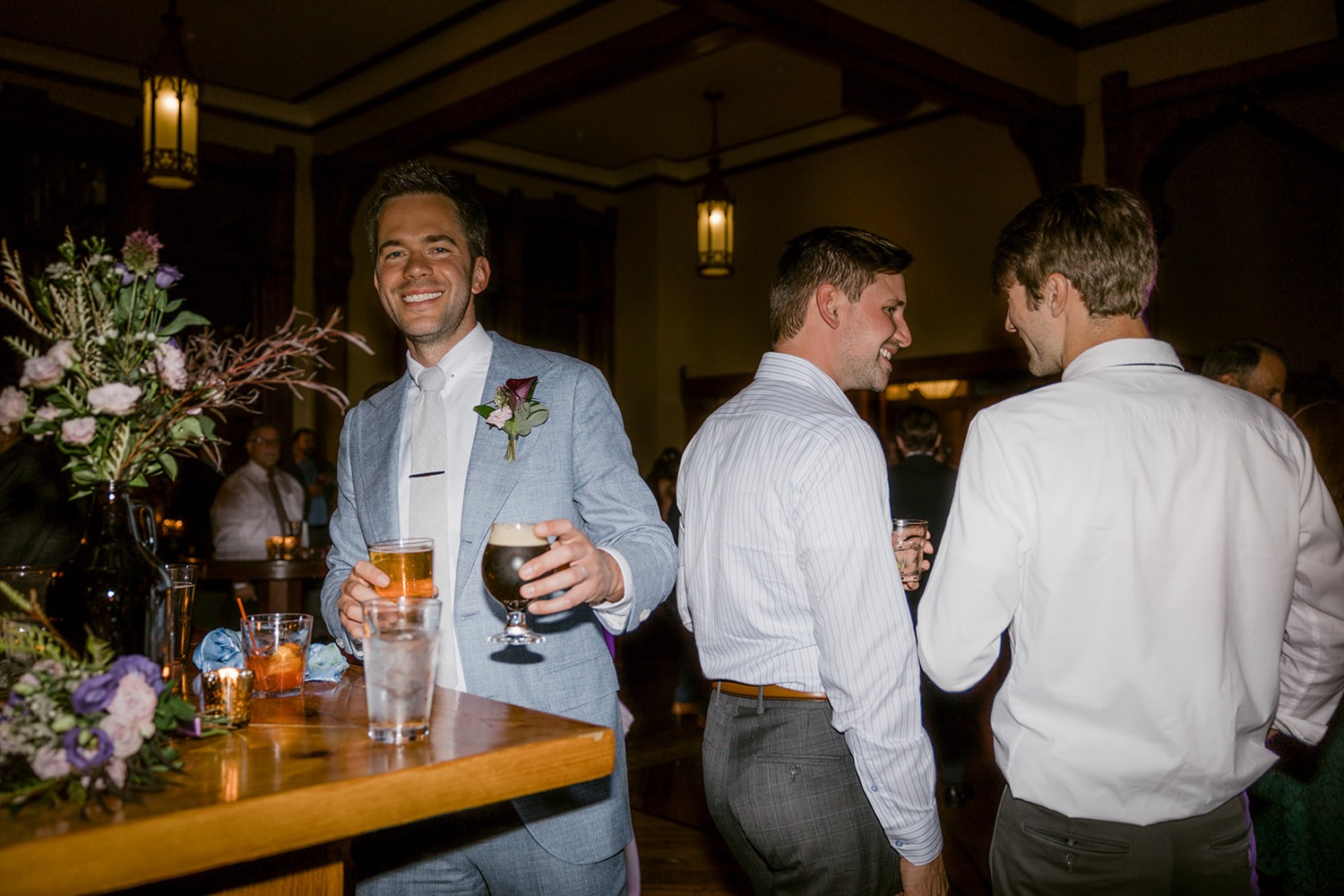 groom smiling with beers wedding reception