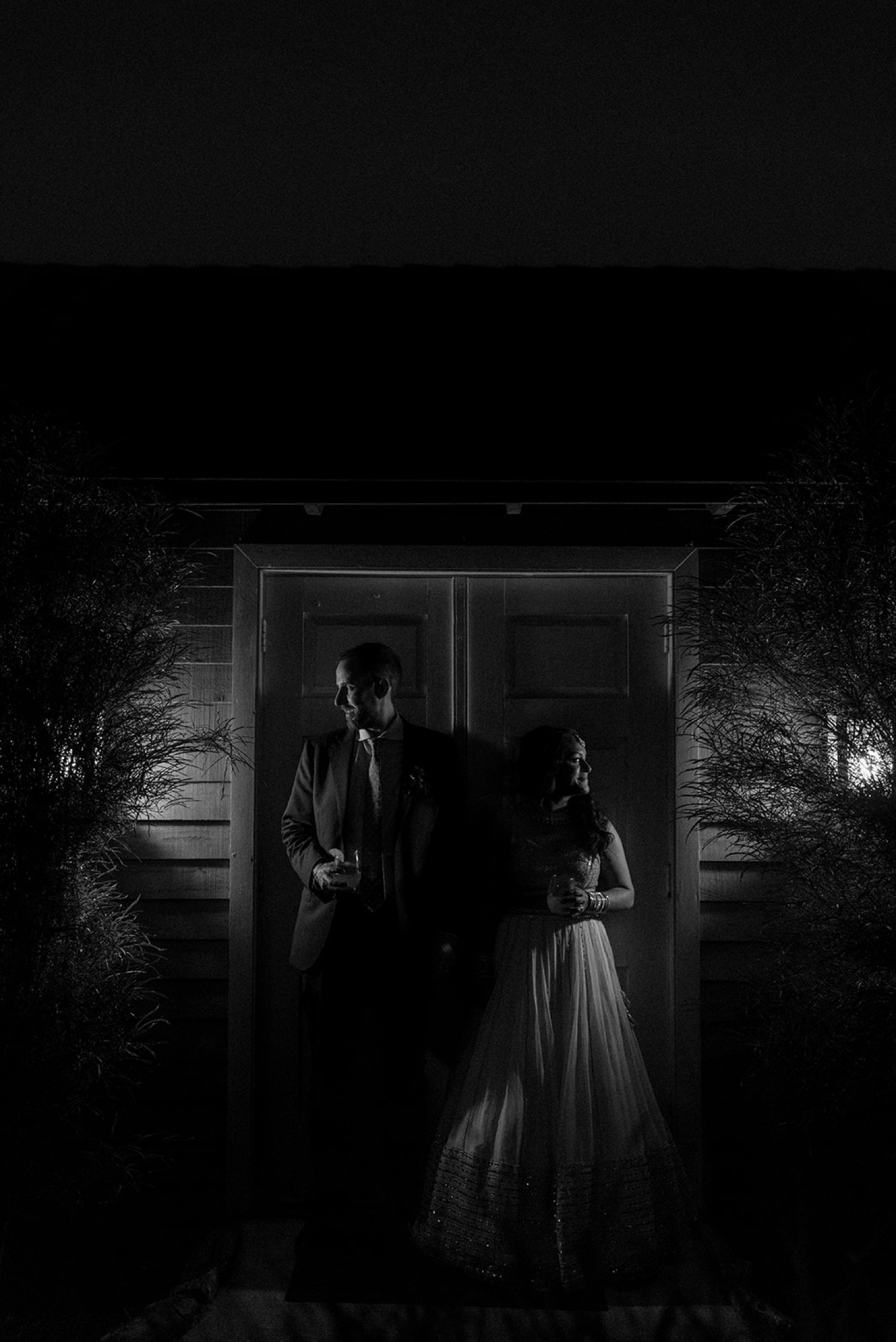 bride and groom shadowy couple portrait in front of doors at night Historic Acres of Hershey Wedding