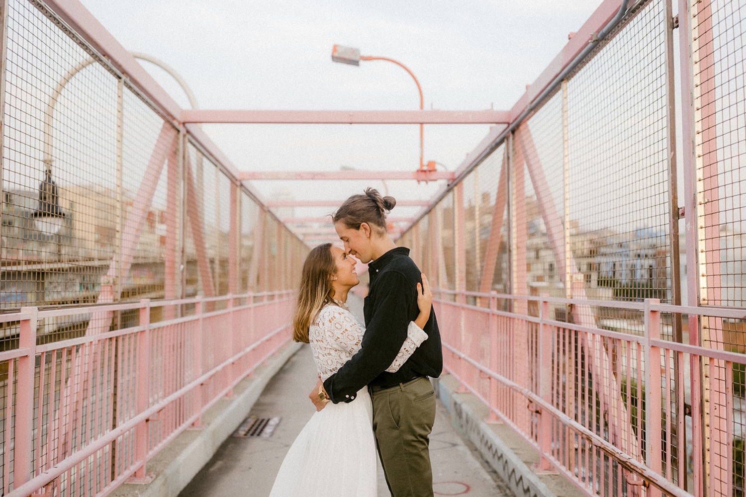 couple hugging on pink bridge brooklyn
