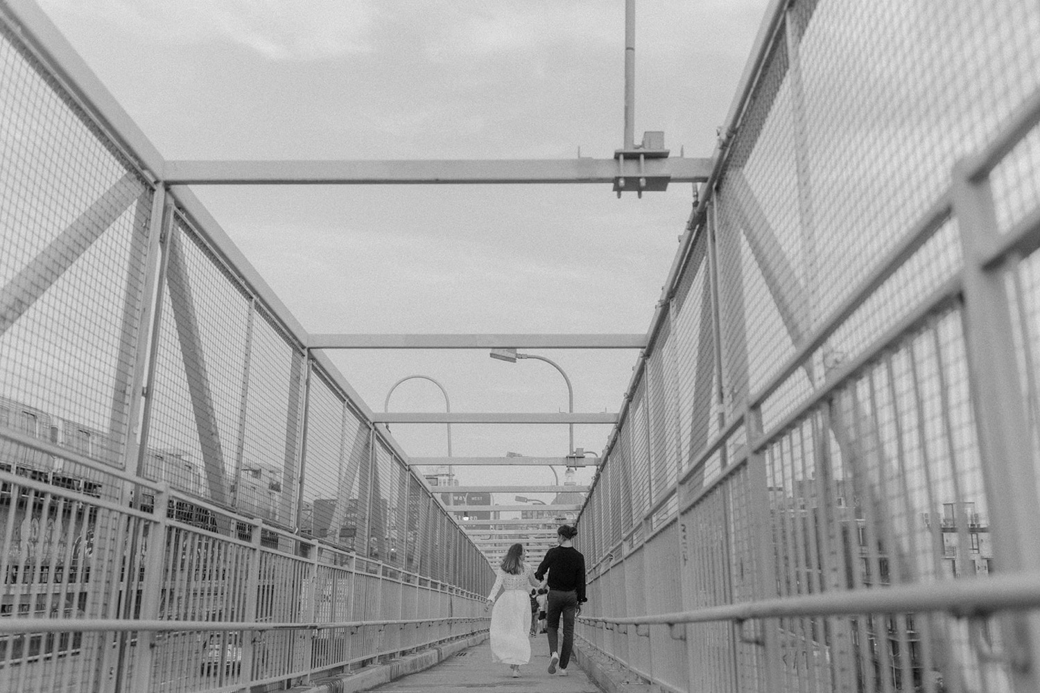 couple running across bridge