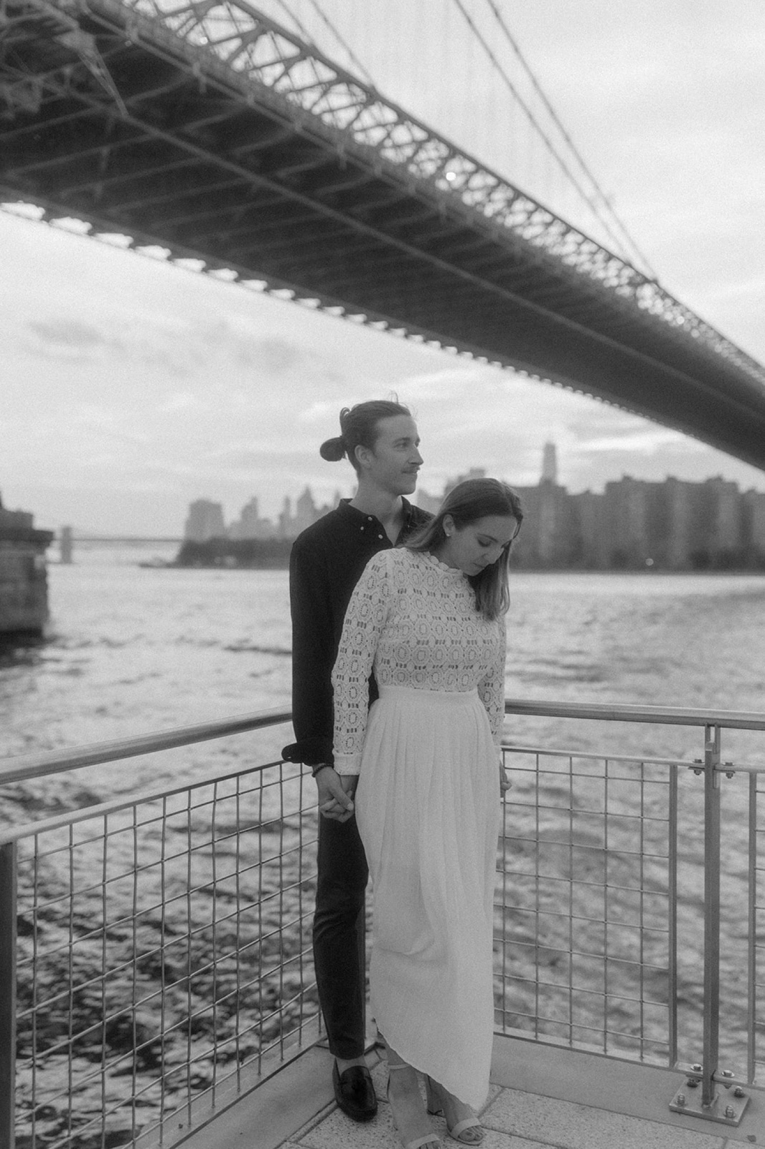 couple standing under brooklyn bridge