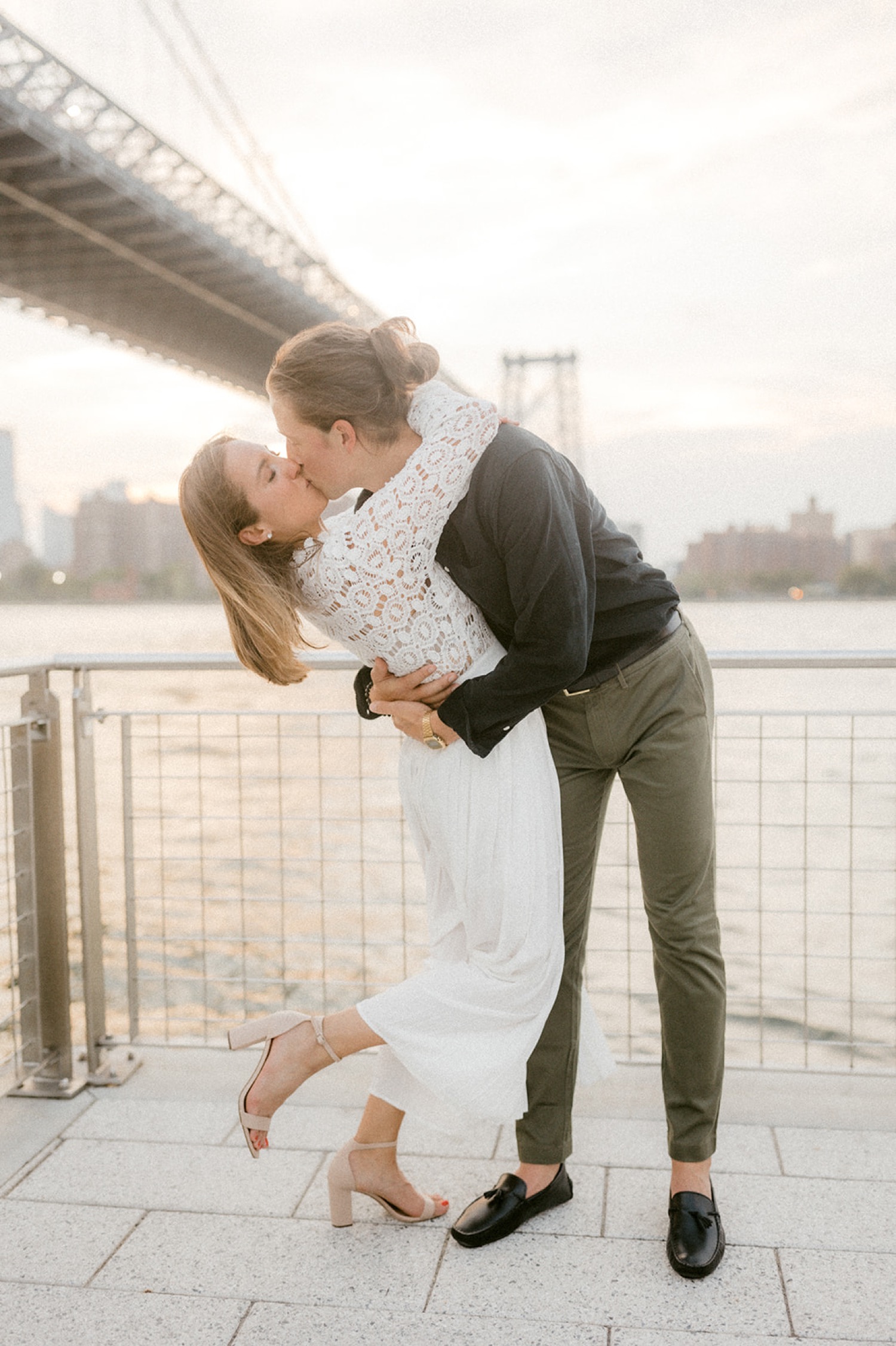 couple kissing under brooklyn bridge engagement session