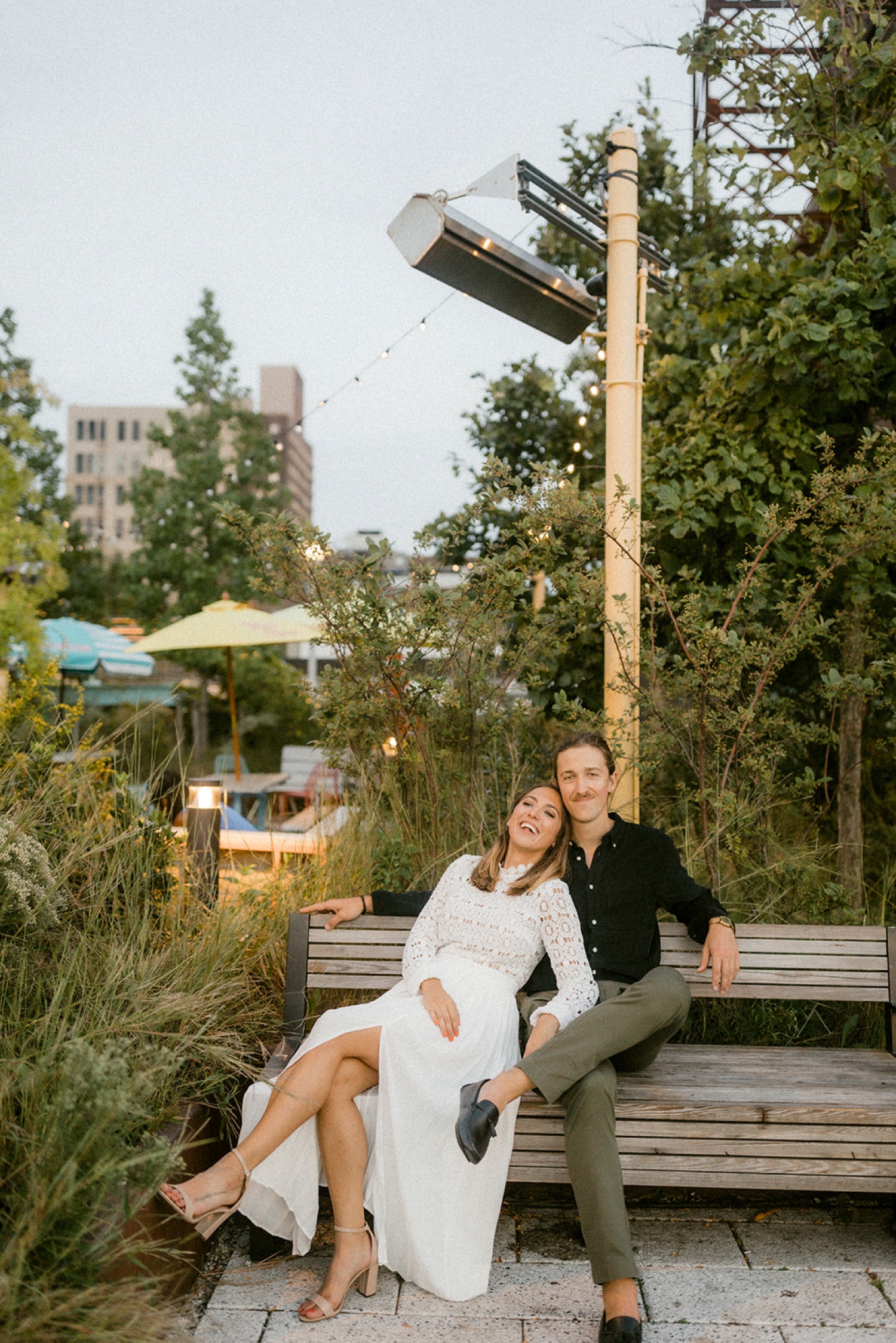 couple sitting on bench laughing casual engagement session